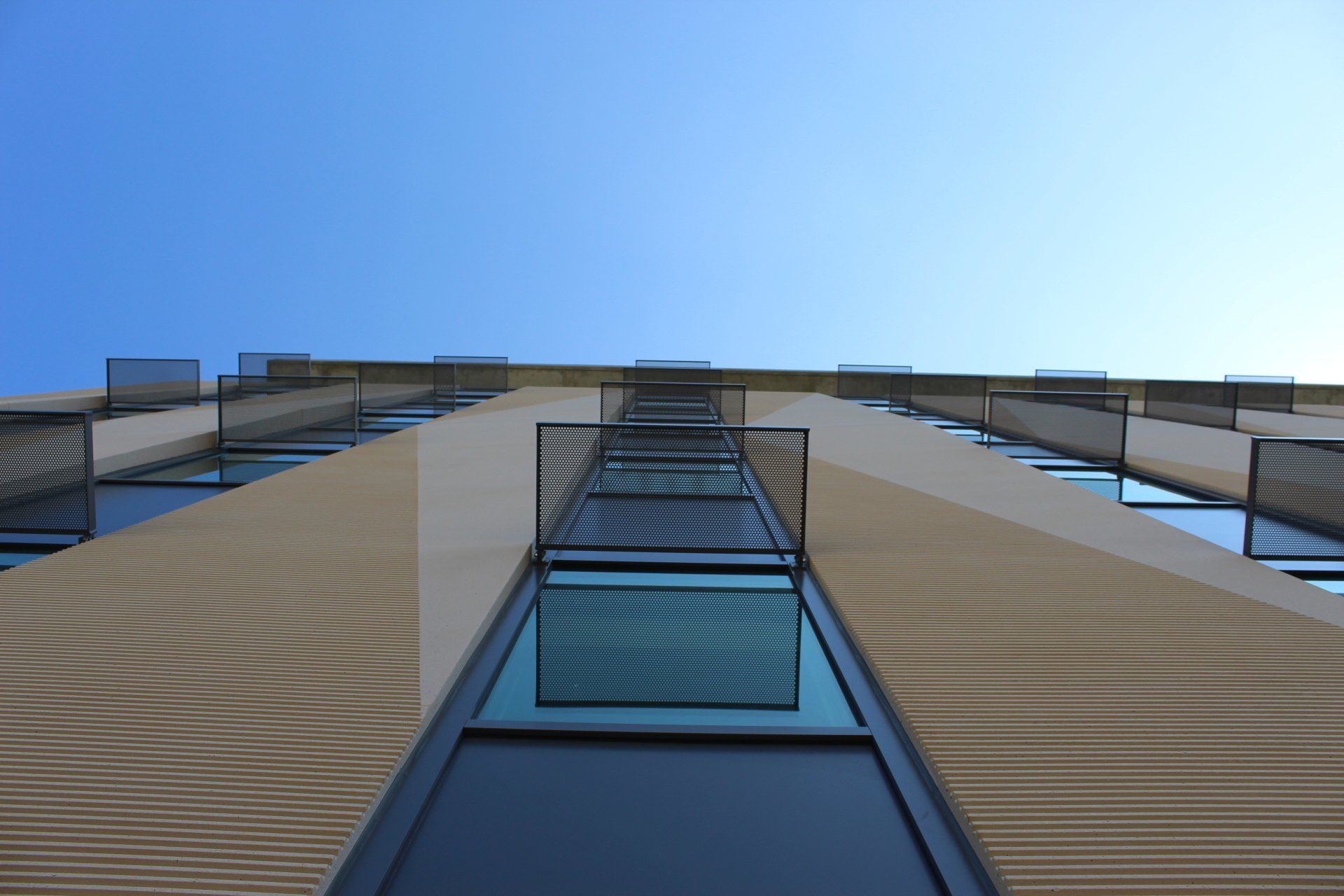 Looking up at a tall building with a blue sky in the background