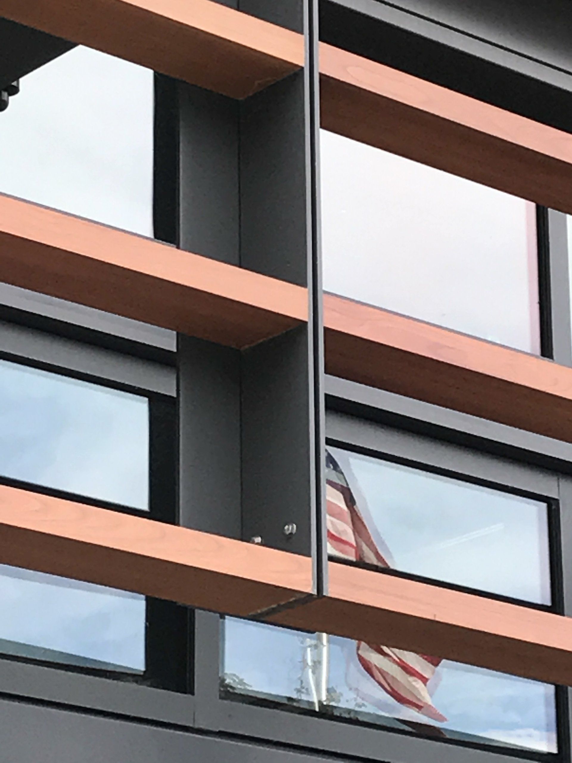 The american flag is reflected in the windows of a building
