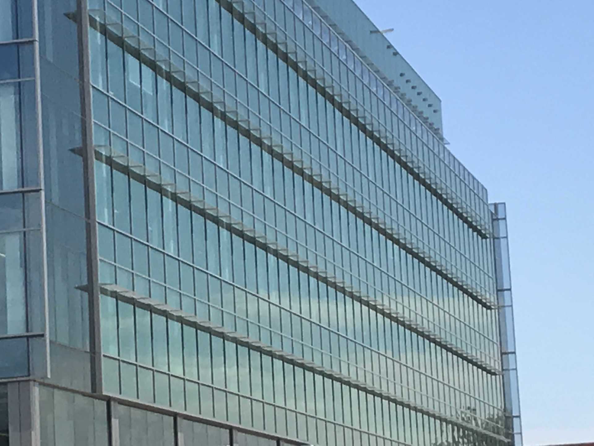 A large building with lots of windows and a blue sky in the background