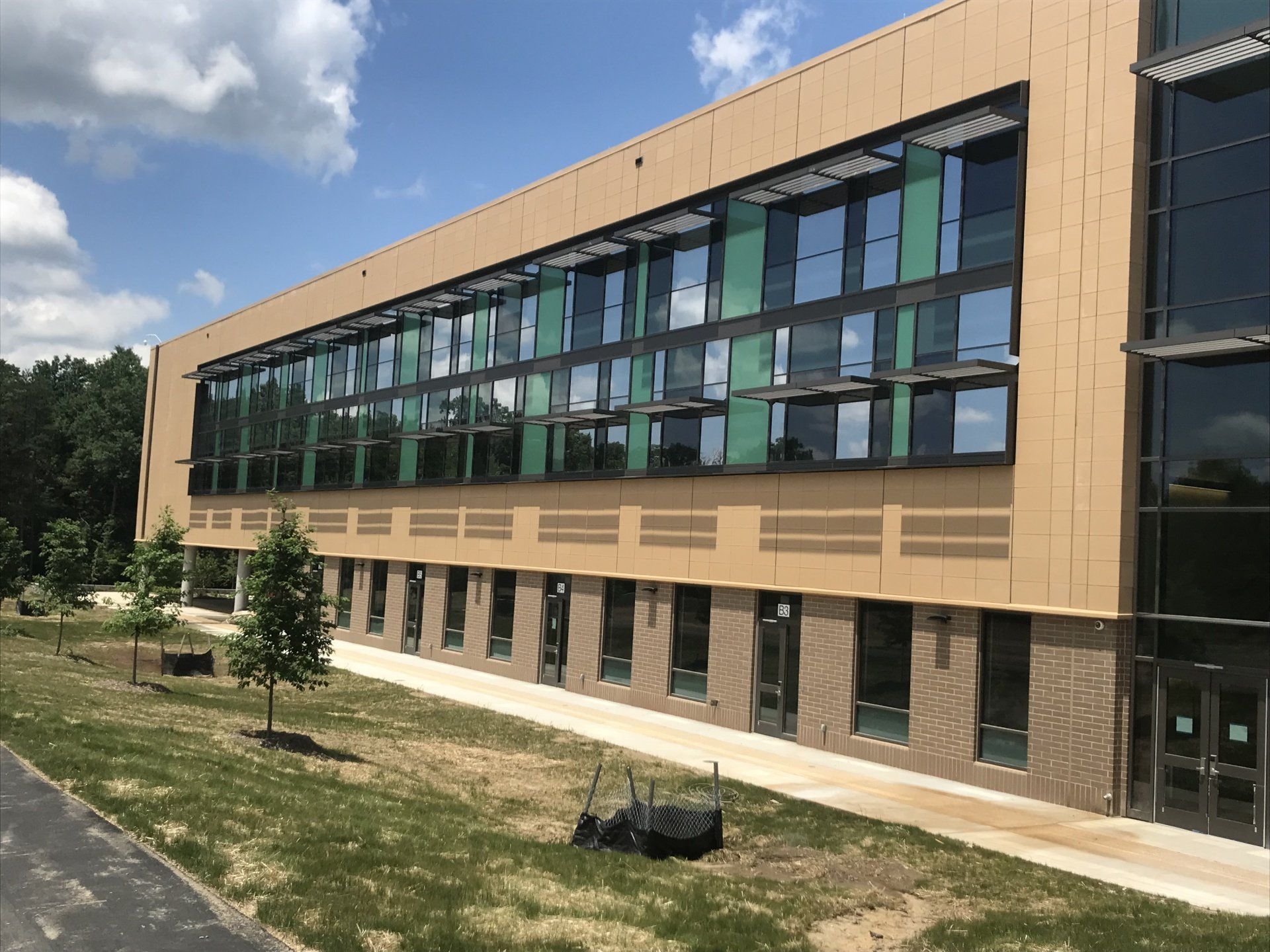 A large building with a lot of windows and trees in front of it.
