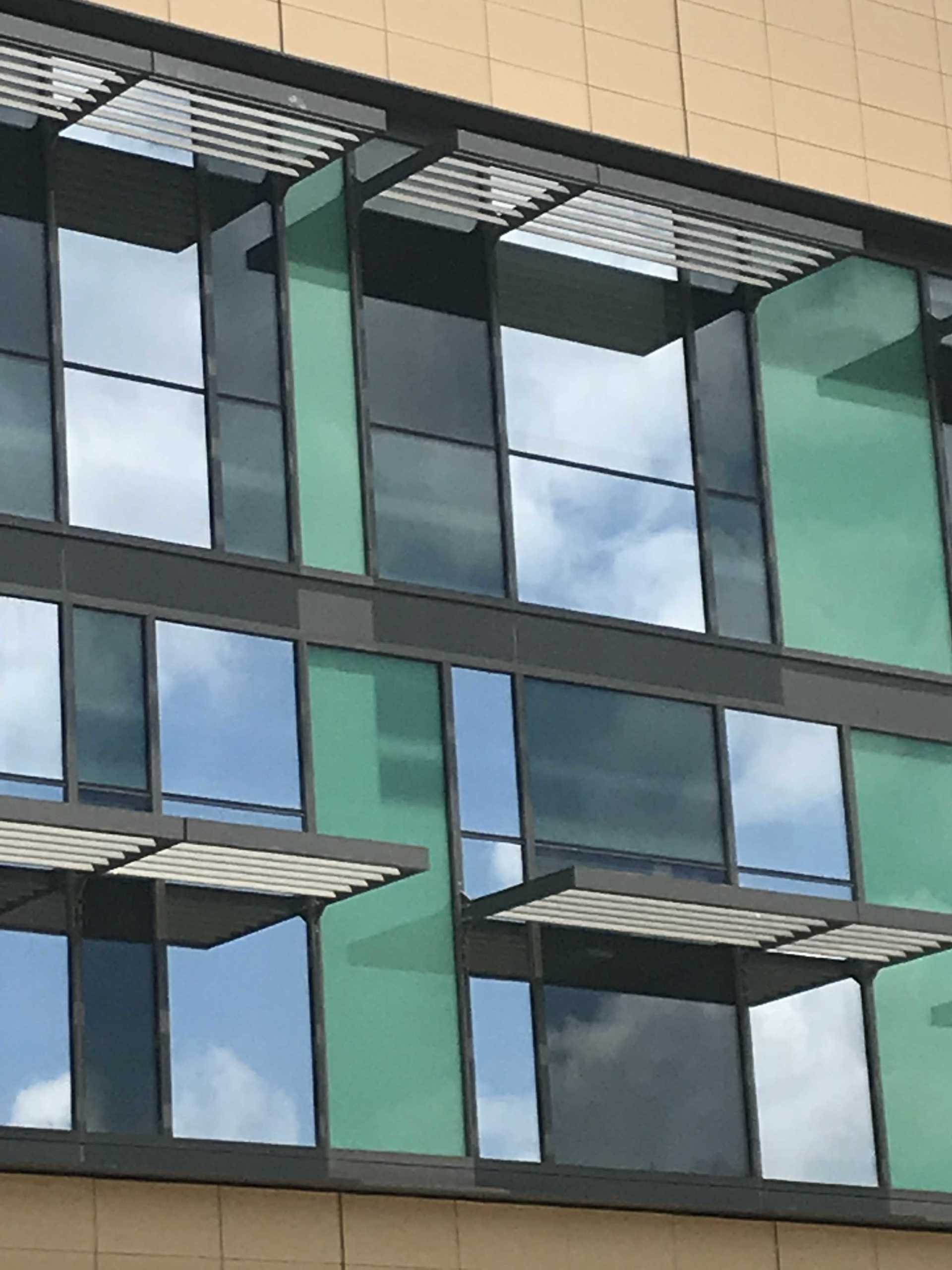 A building with a lot of windows and a reflection of the sky