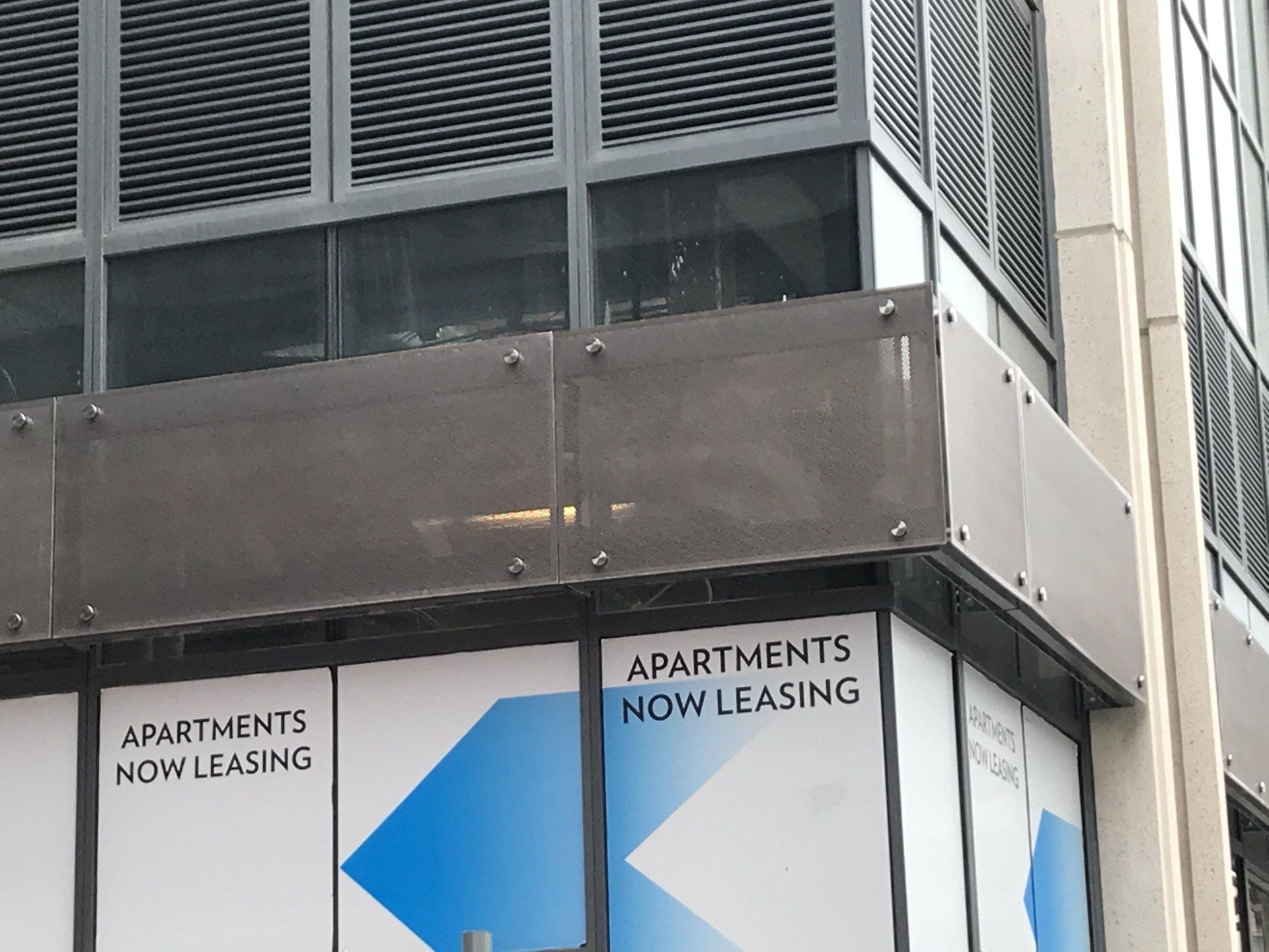 A building with apartments now leasing on the windows