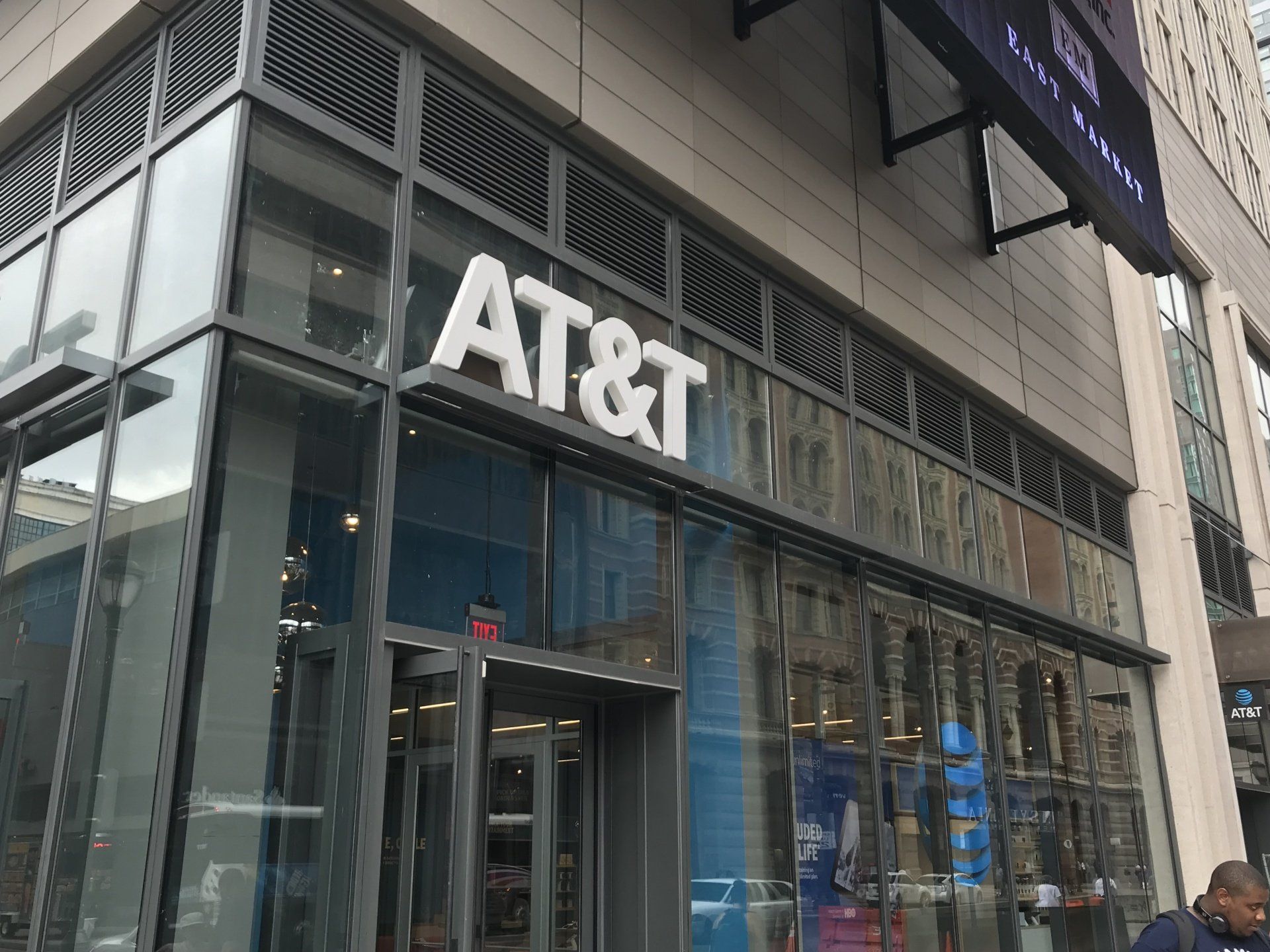 a man is walking in front of an at & t store