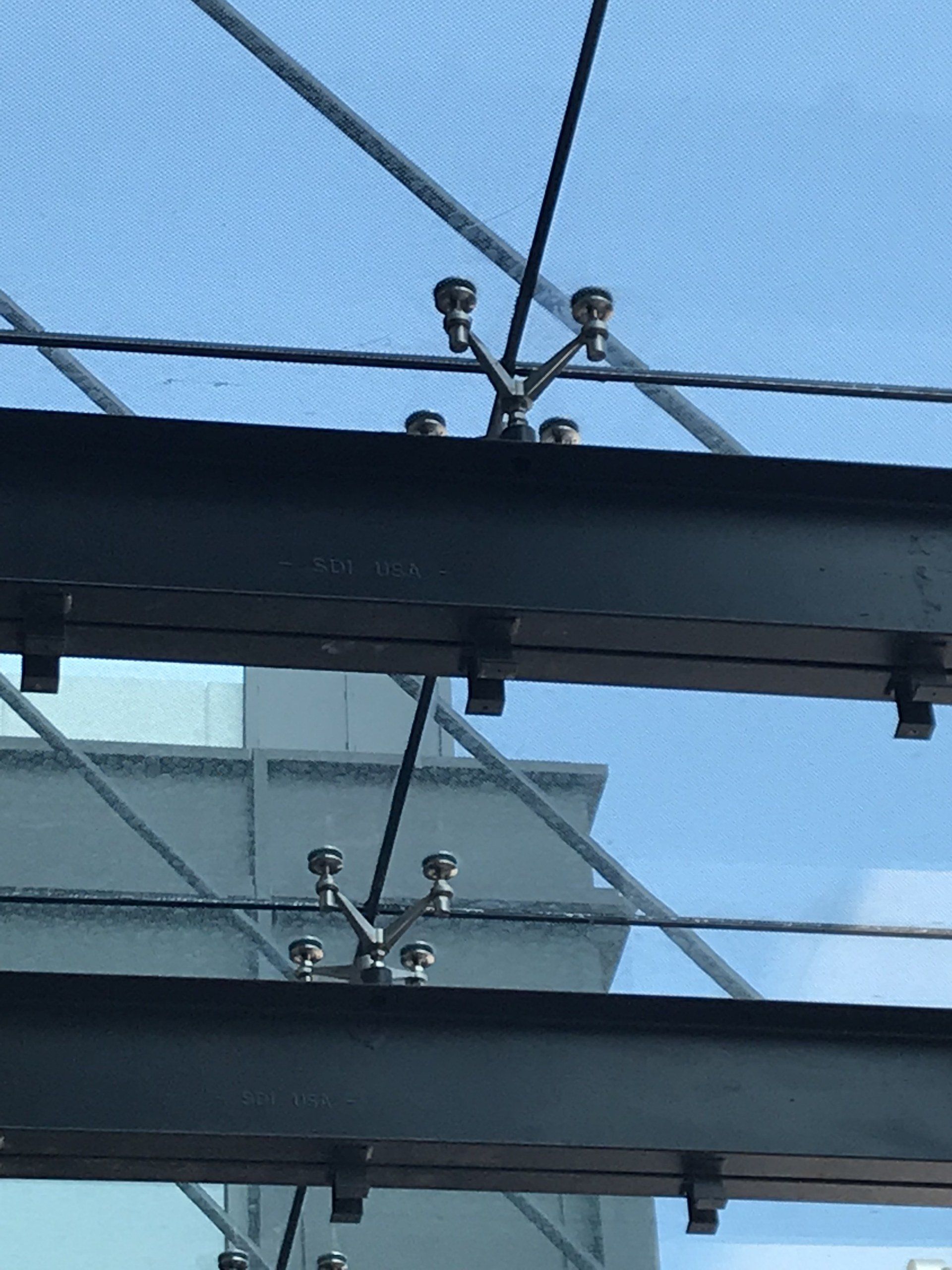 A close up of a metal structure with a blue sky in the background.