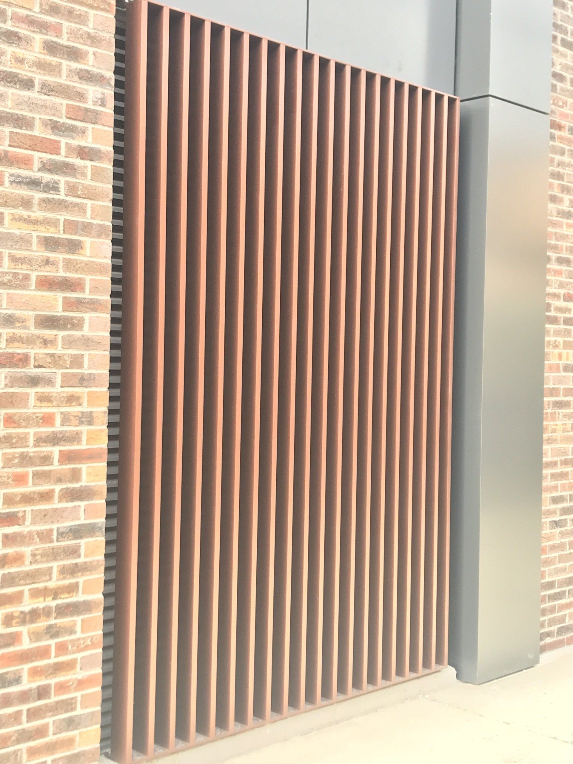 A brick wall with a wooden fence in front of it.