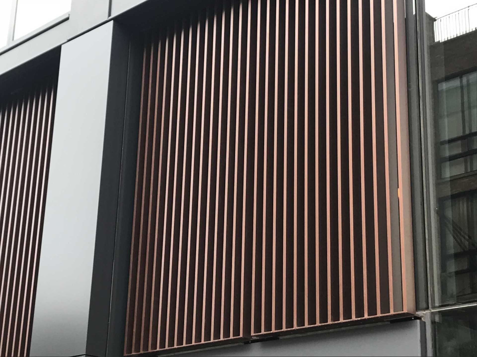 A building with a row of vertical bars on the side of it.