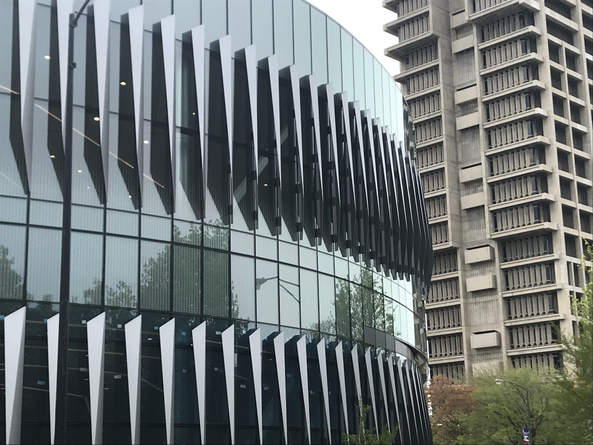 A building with a lot of windows and a tall building in the background