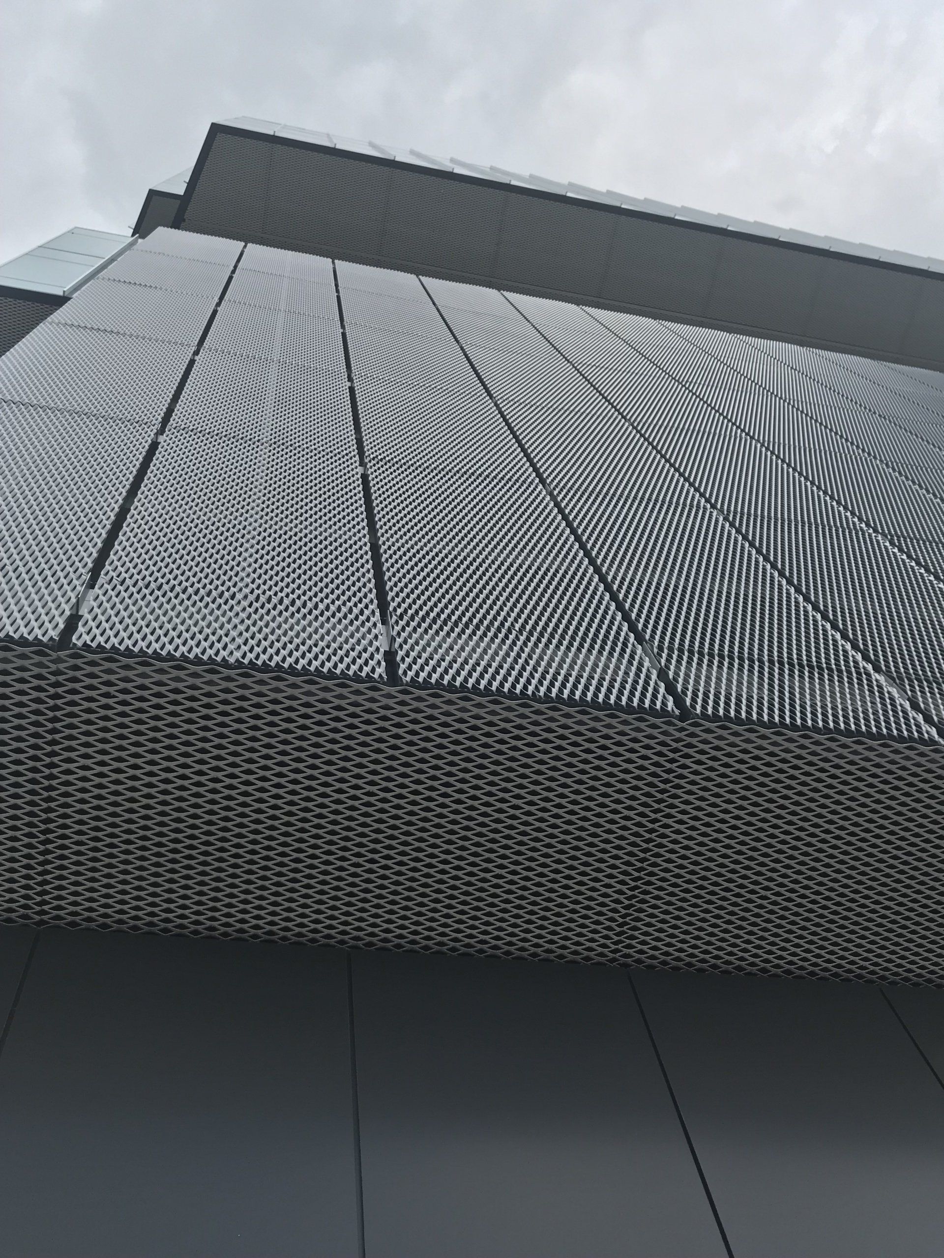 Looking up at a building with a perforated metal facade