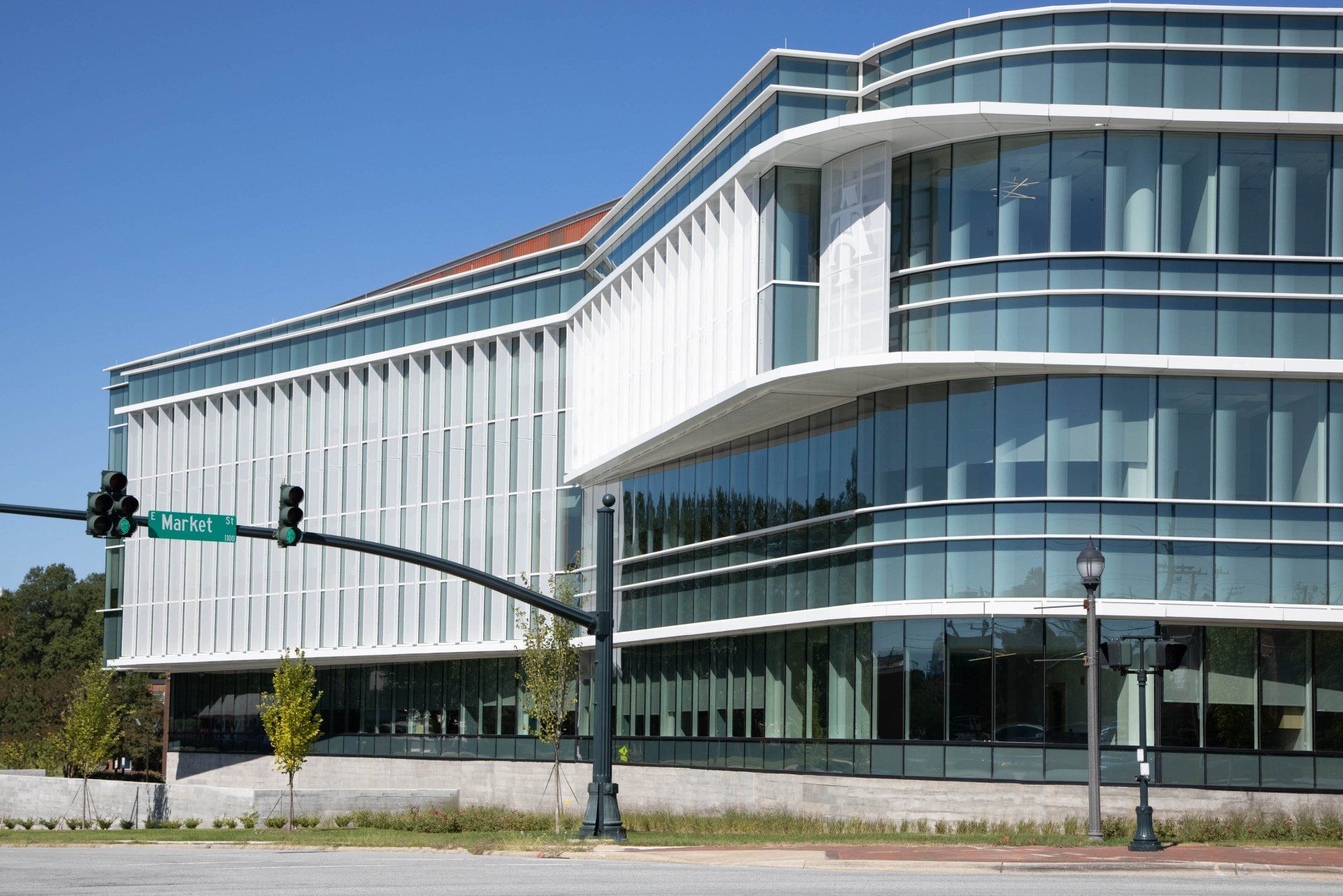 A large building with a lot of windows and a traffic light in front of it.