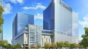 A large building with a lot of windows is surrounded by trees.