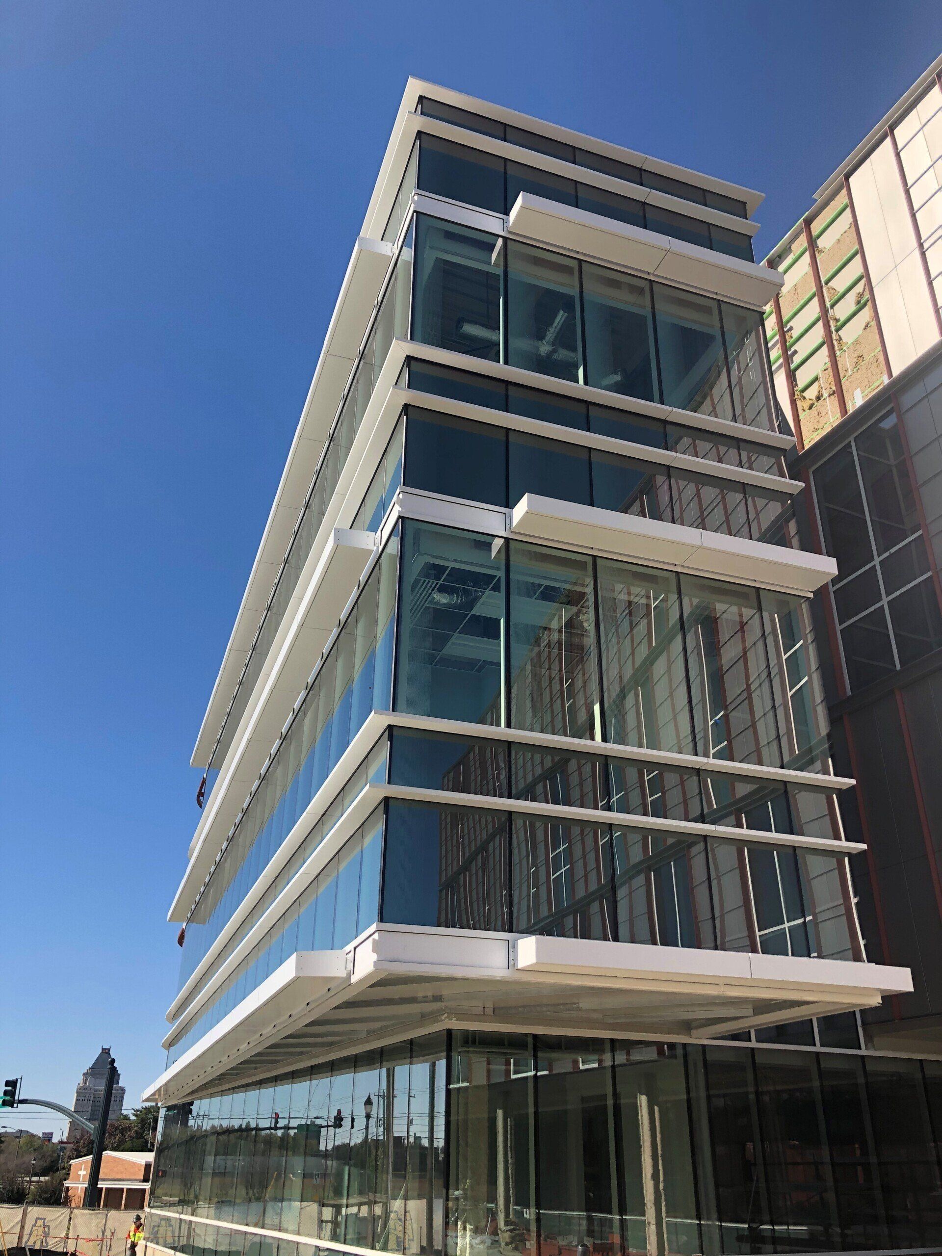 A large building with a lot of windows and a blue sky in the background
