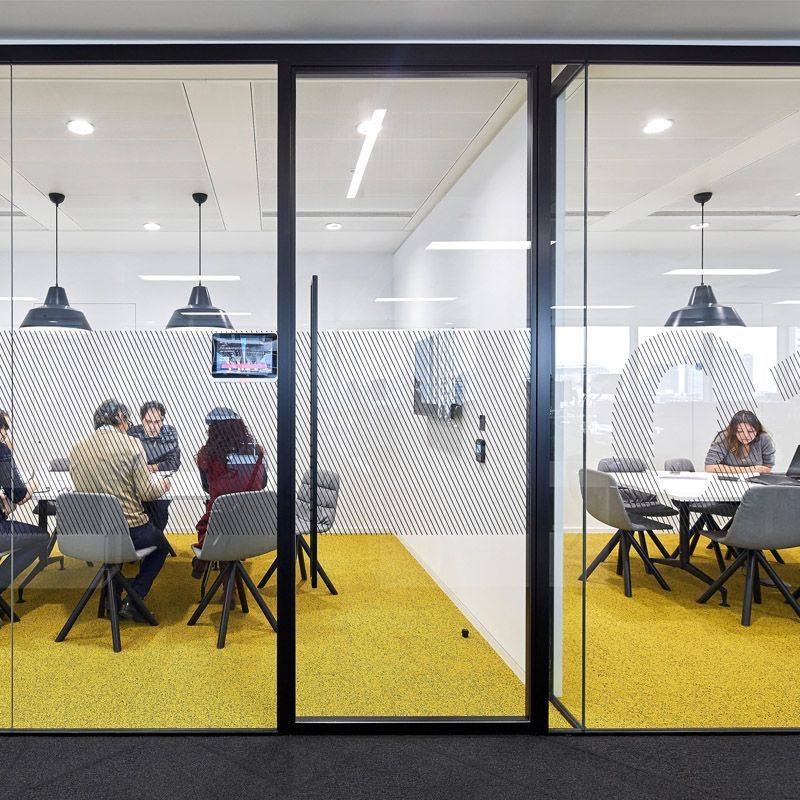 A group of people are sitting at tables in a conference room.