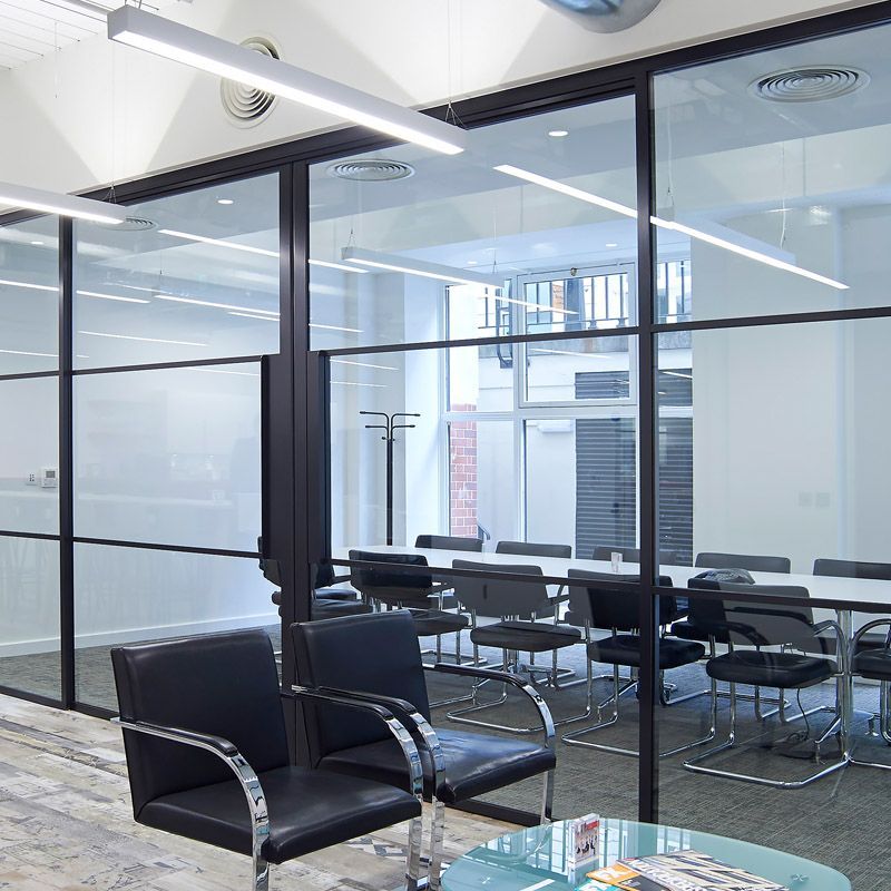 A waiting room with chairs and a glass table