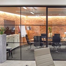 A conference room with a brick wall and sliding glass doors.