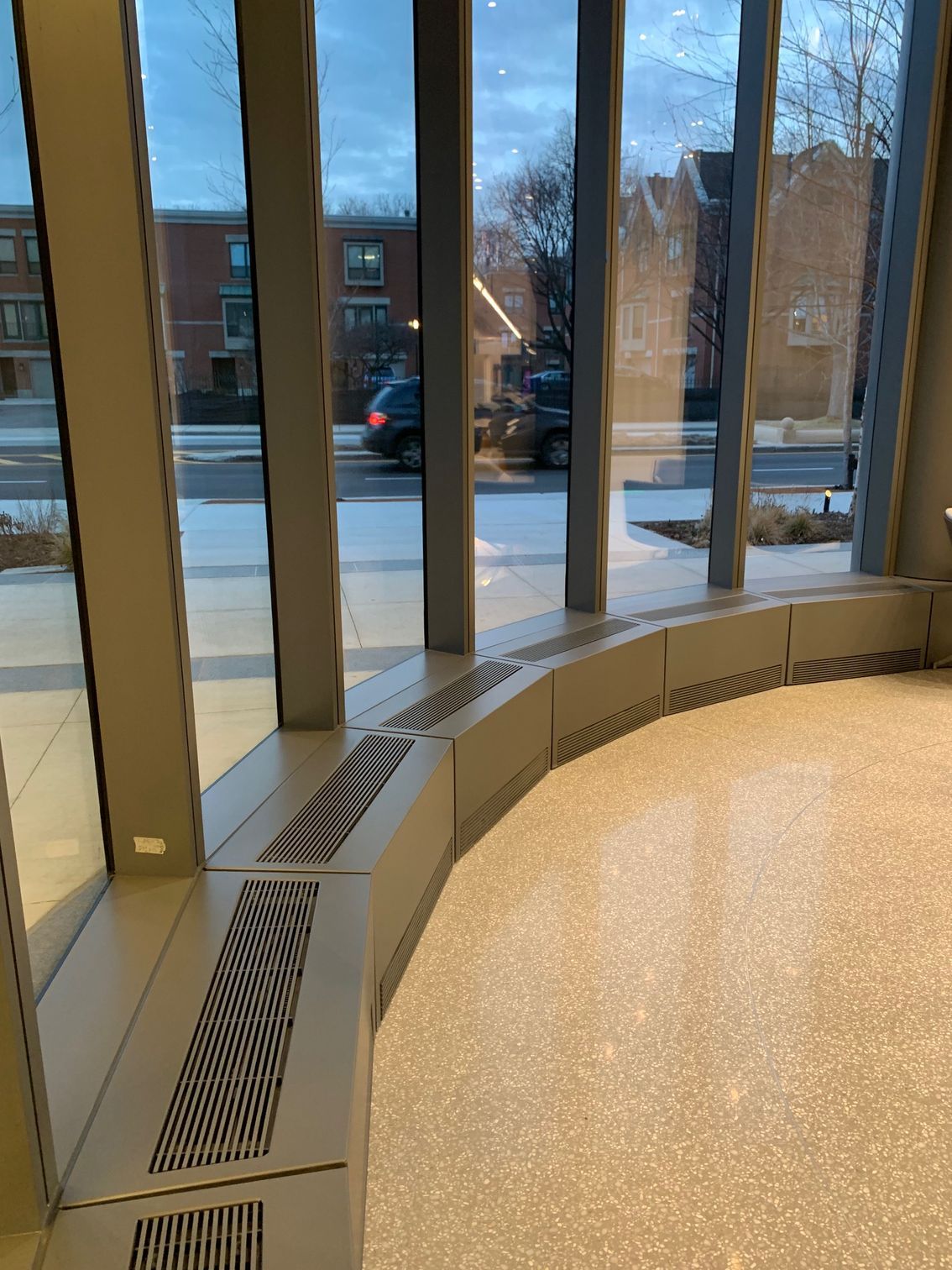 A room with a lot of windows and a radiator on the floor.