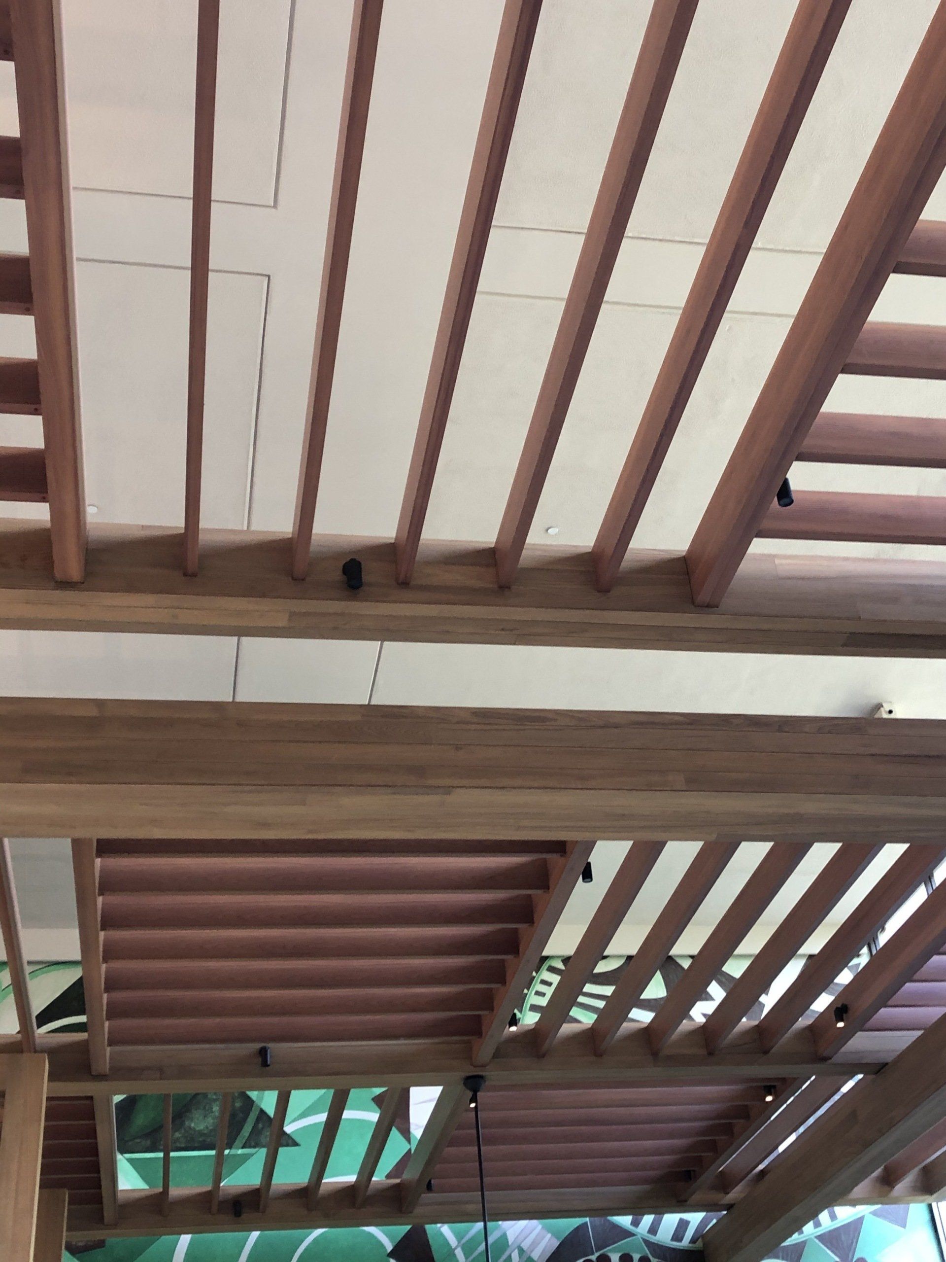 A ceiling with wooden beams and a ceiling fan