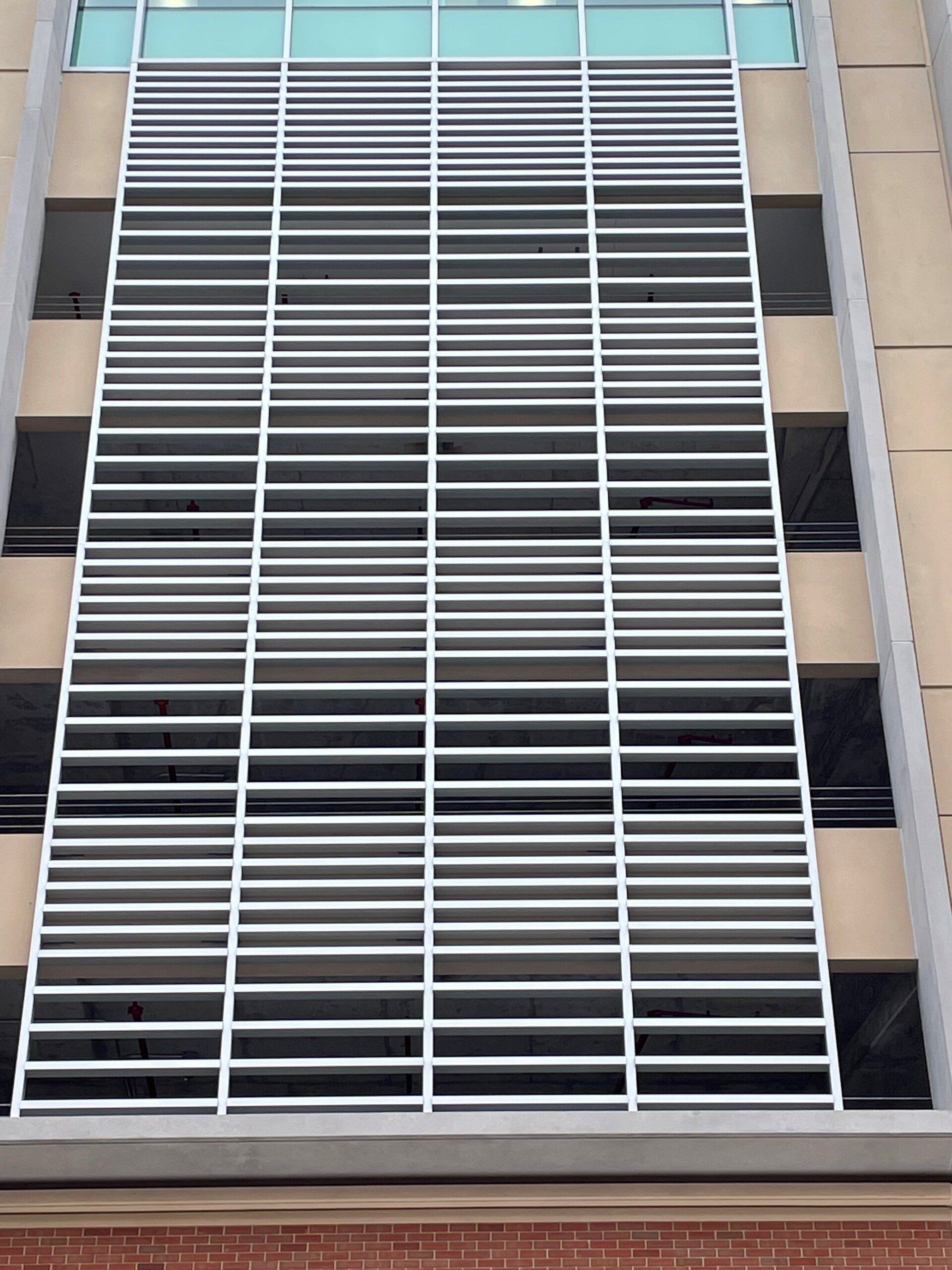 A building with a lot of windows and a fence on the side of it.