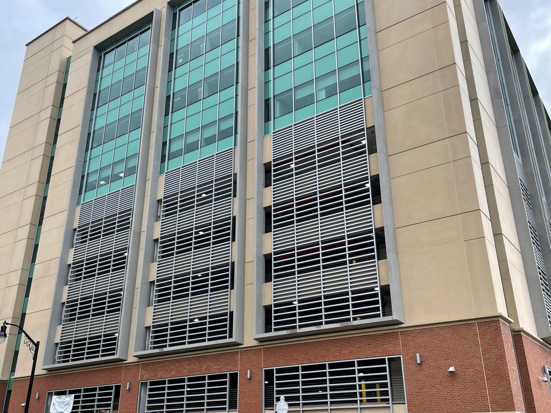 A tall building with lots of windows and a parking garage