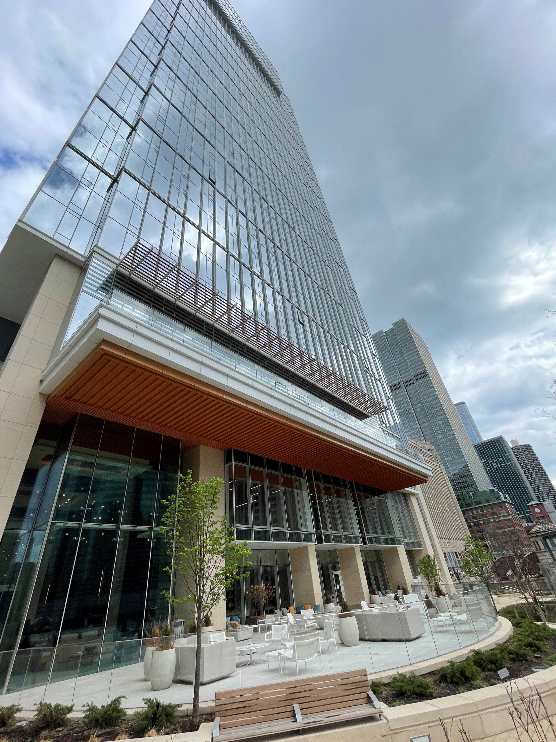 A tall building with a lot of windows and a patio in front of it.
