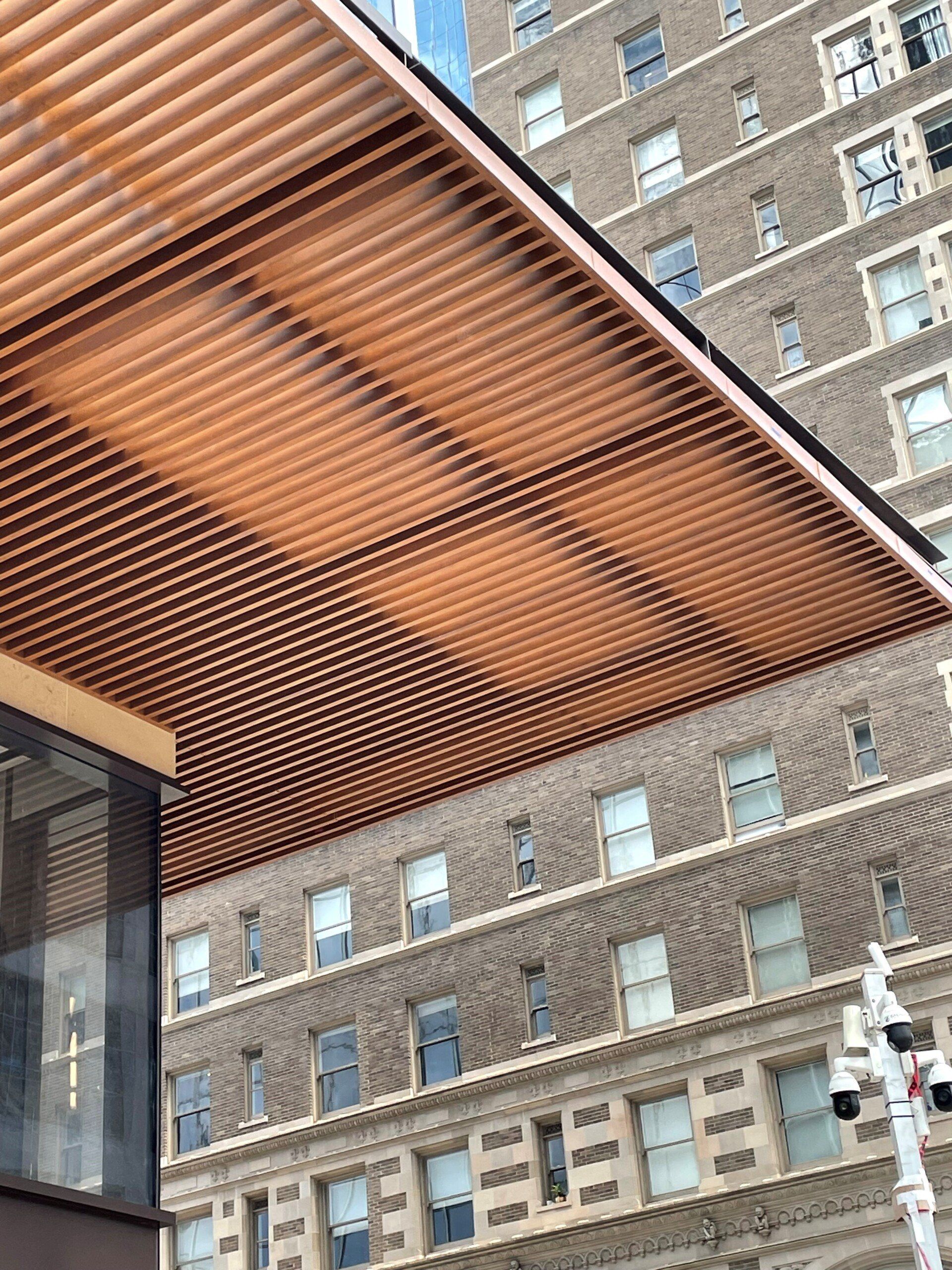 A building with a wooden ceiling and a brick building in the background