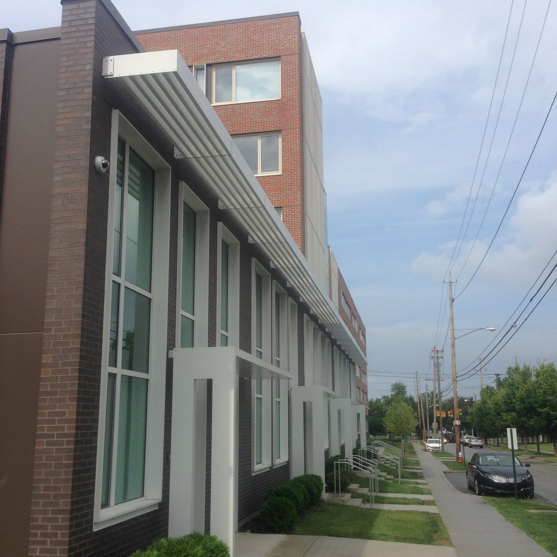 A building with a lot of windows and a car parked in front of it