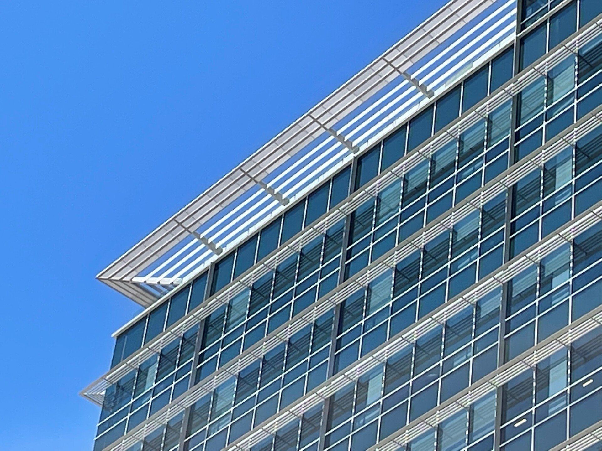 A tall building with lots of windows against a blue sky