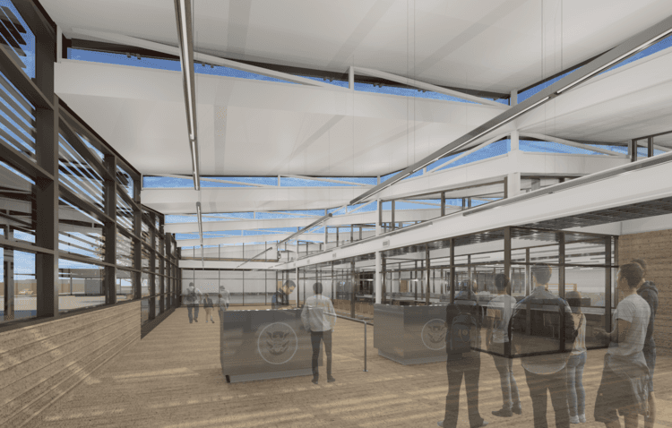 A group of people are standing in a large room with a lot of windows.