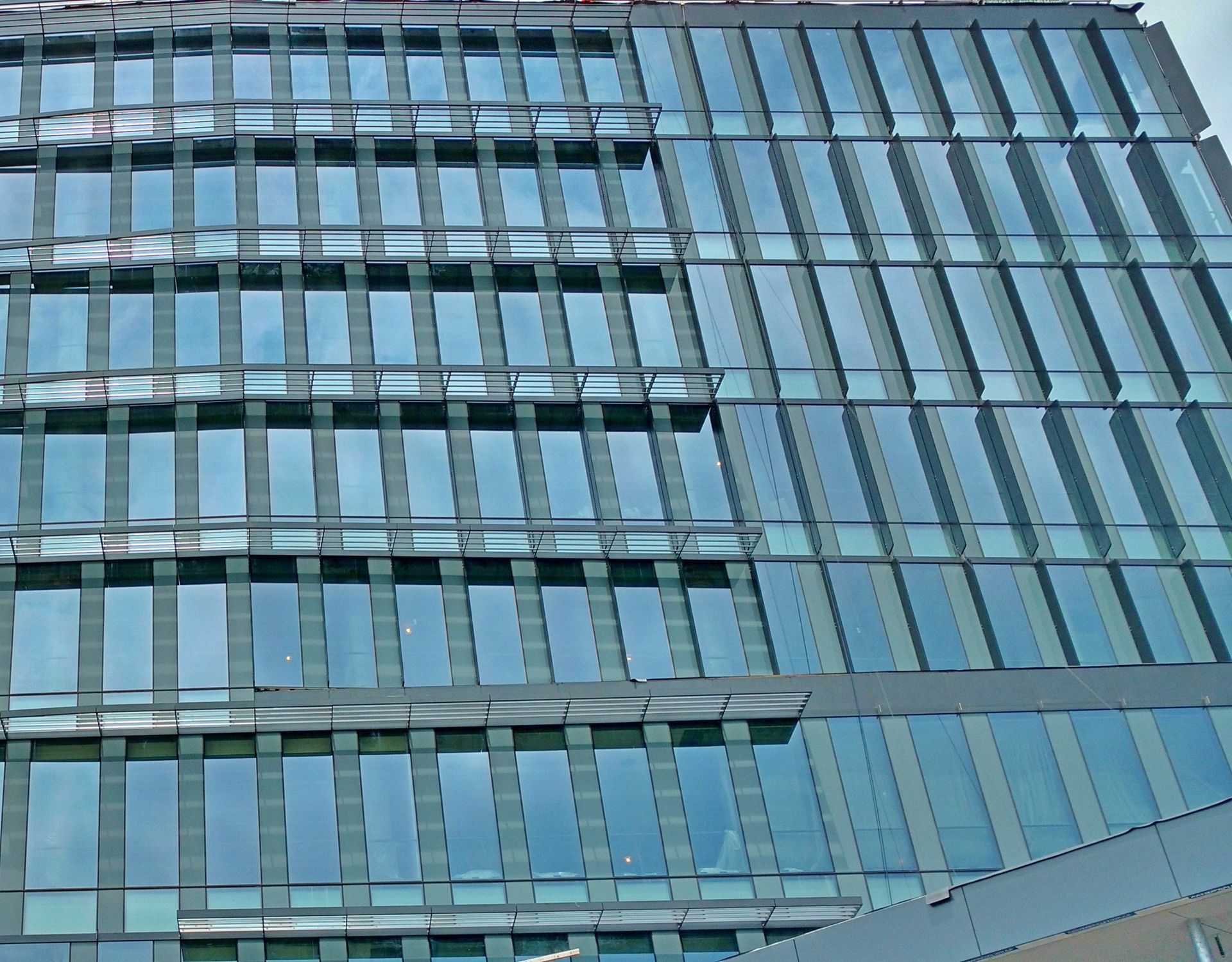 A tall building with a lot of windows and a blue sky in the background