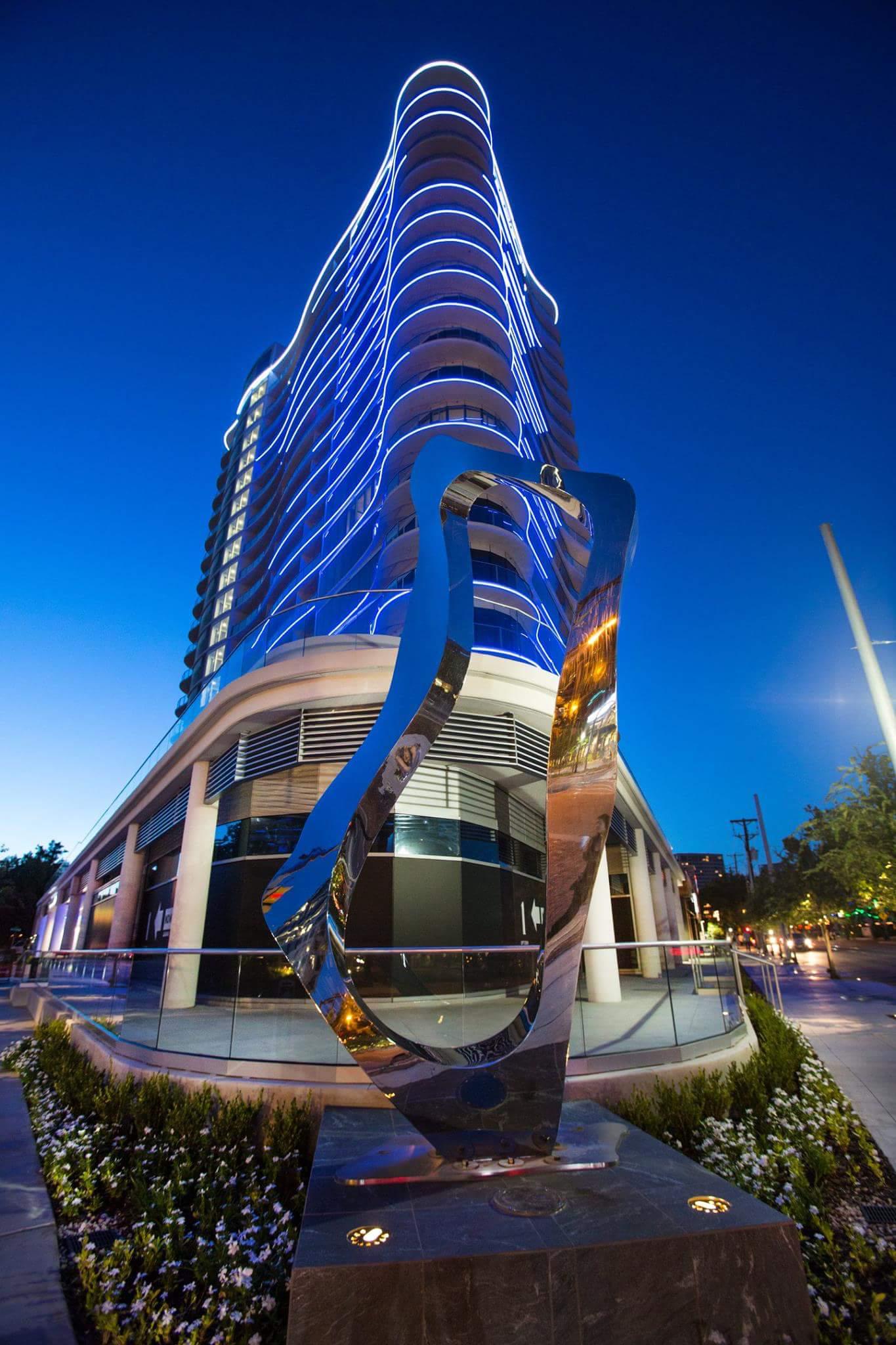 A large building with a statue in front of it at night.
