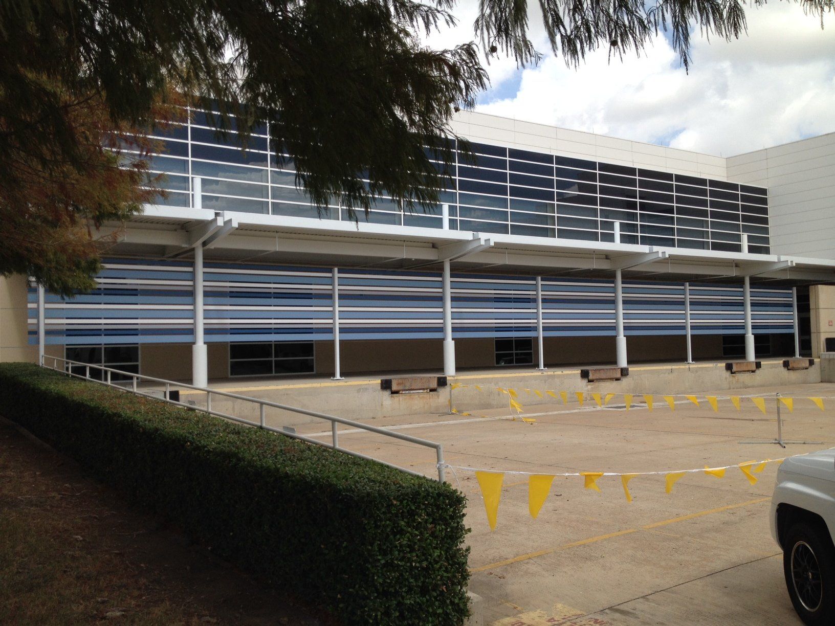 A white truck is parked in front of a large building