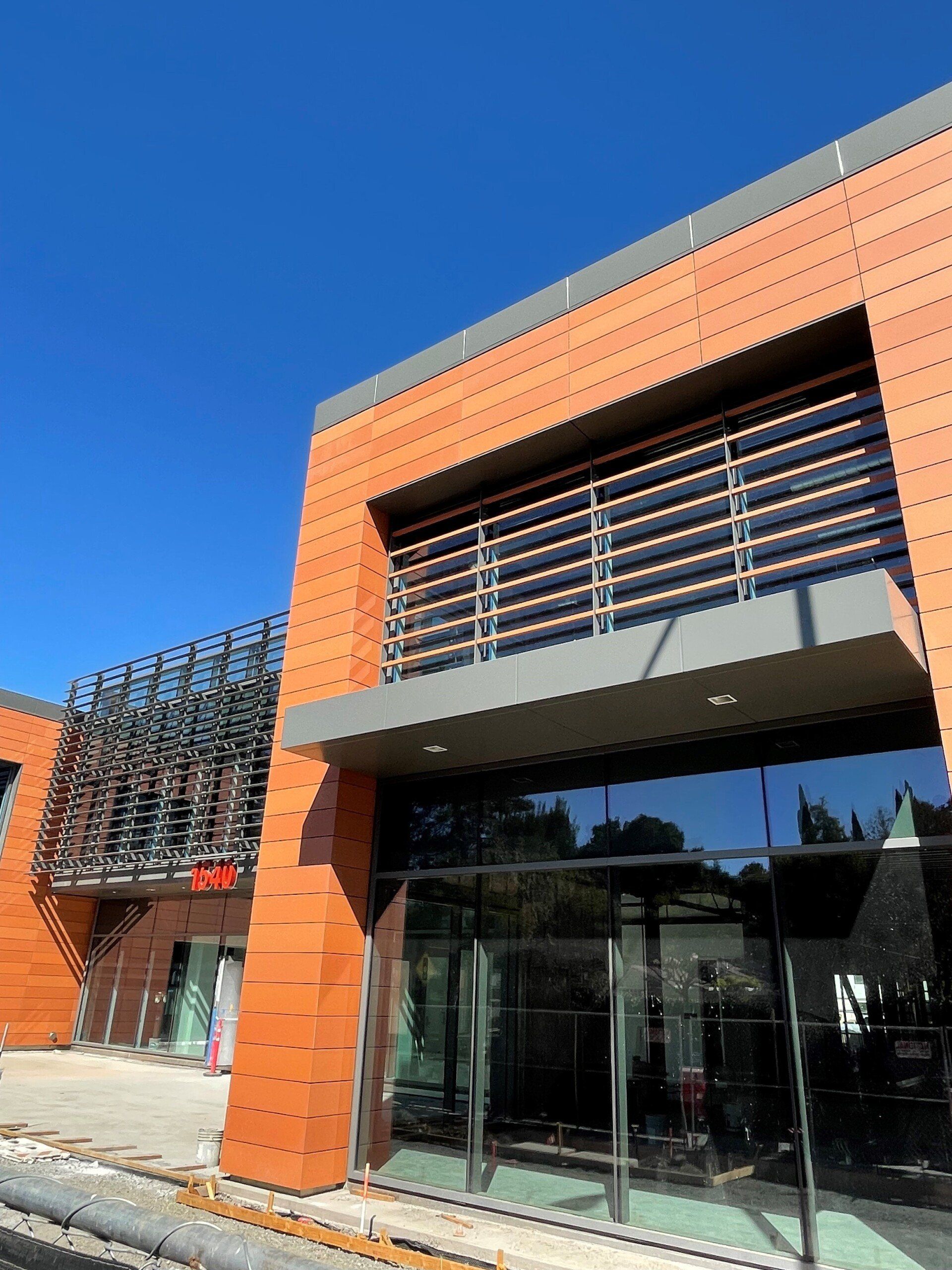 A brick building with a balcony and a blue sky in the background
