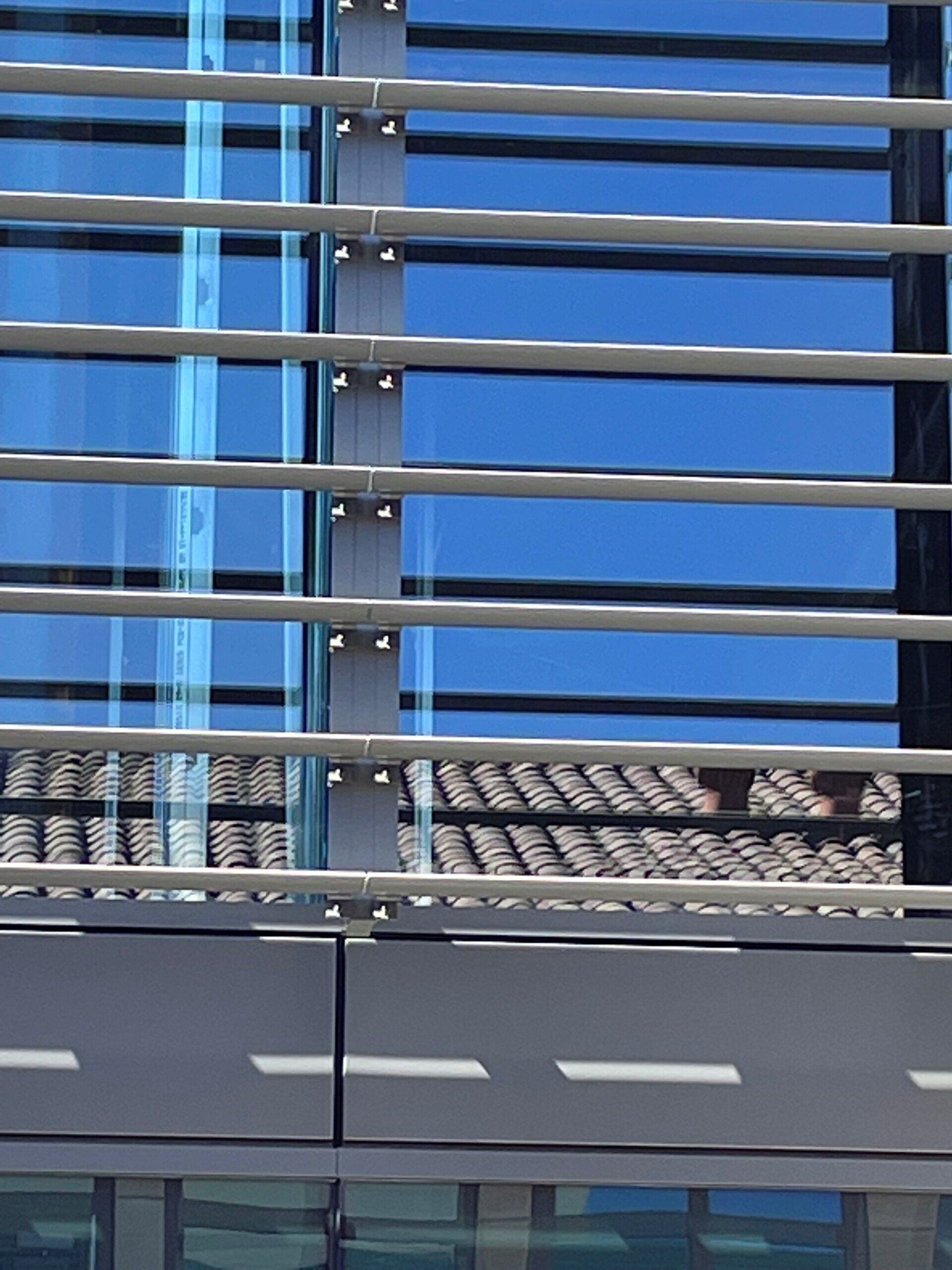 A building with a blue sky reflected in the windows