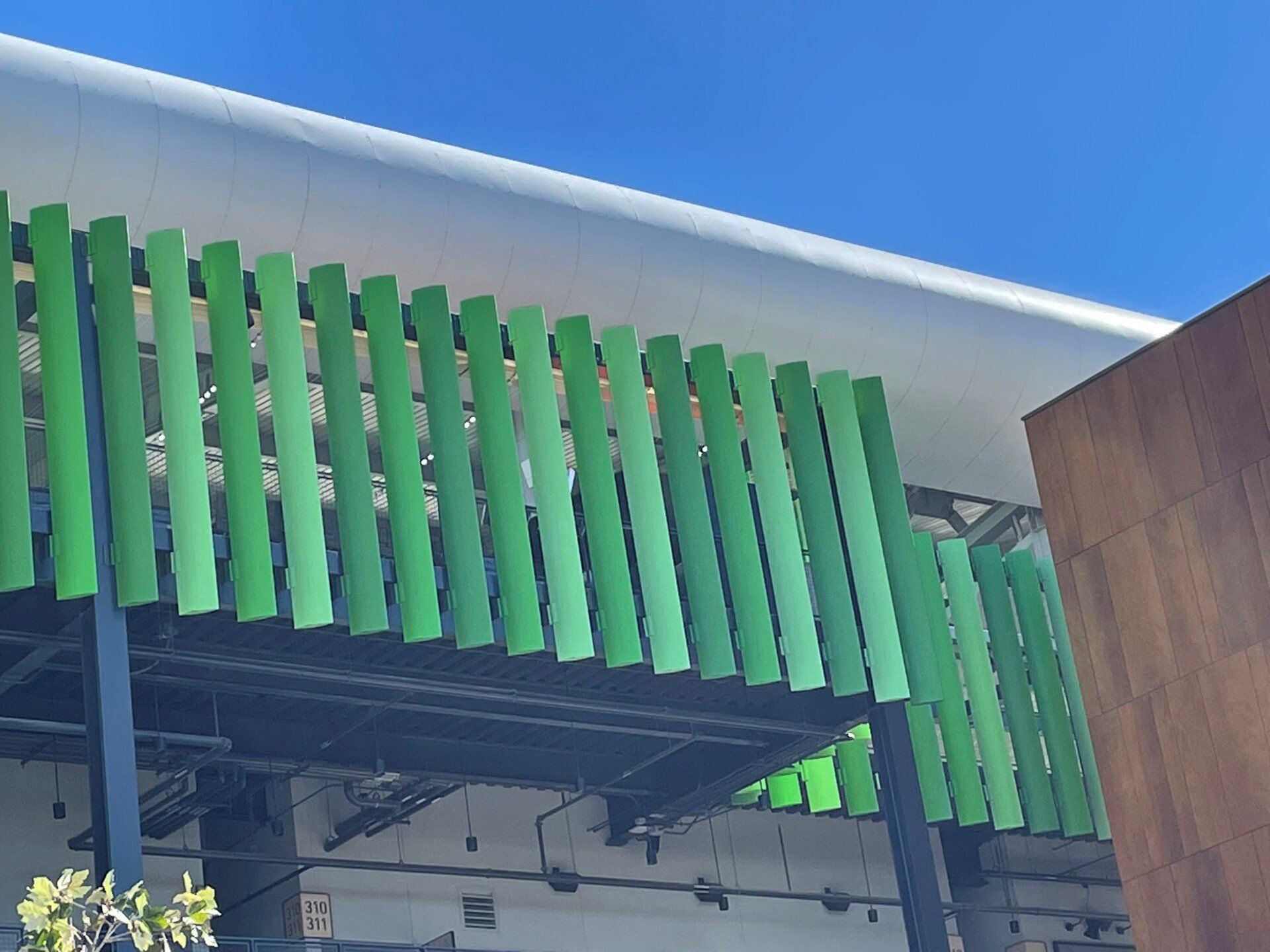 A green fence is surrounding a building with a blue sky in the background.