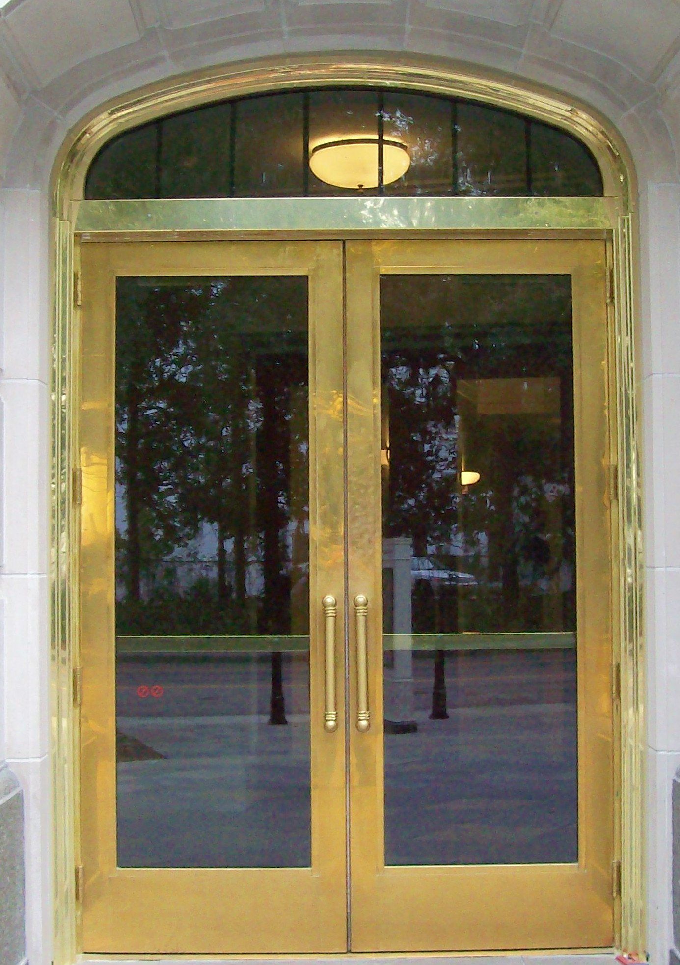 A gold door with a stained glass window above it