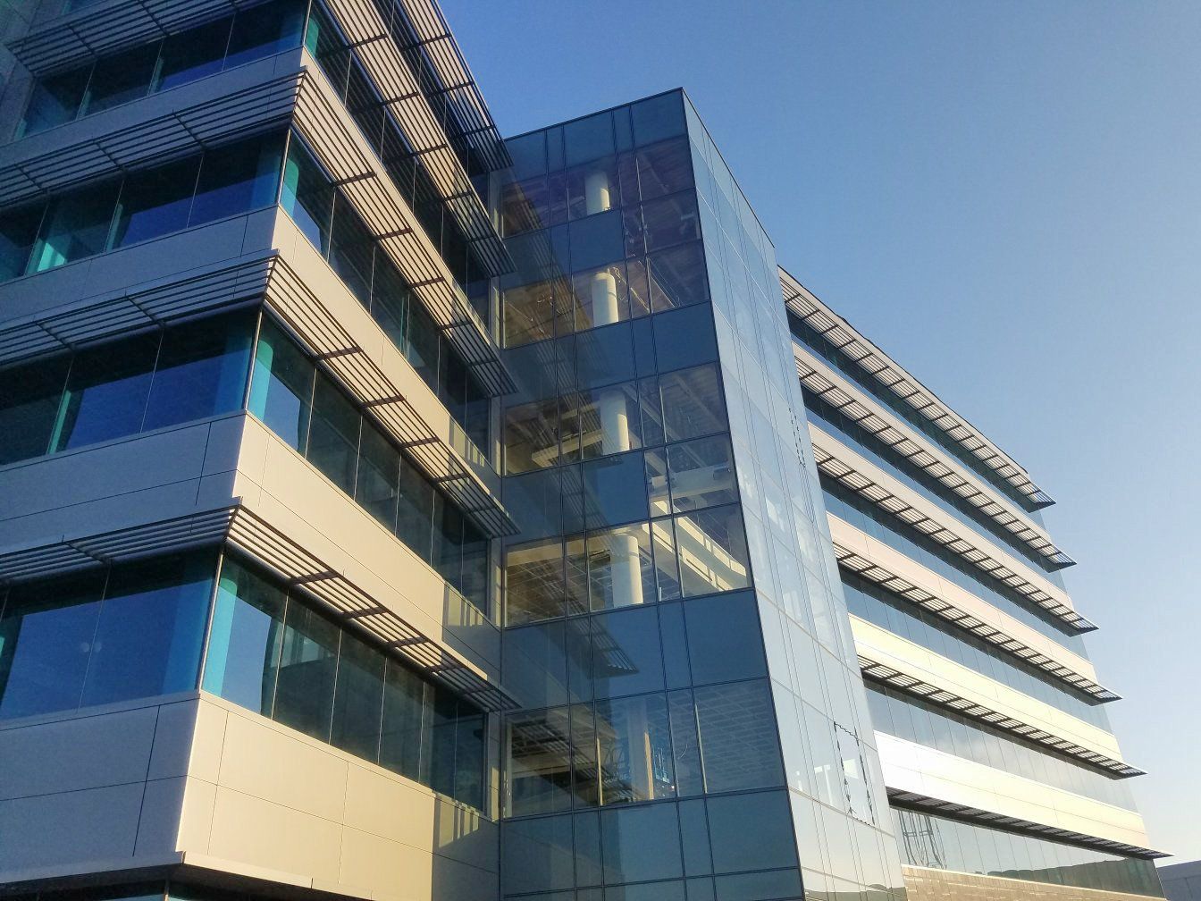 A tall building with lots of windows and a blue sky in the background