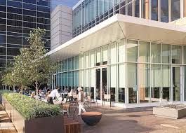 An artist 's impression of a building with a patio in front of it.