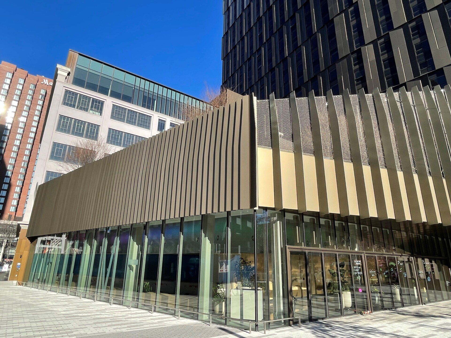 A large building with a lot of windows and a blue sky in the background.