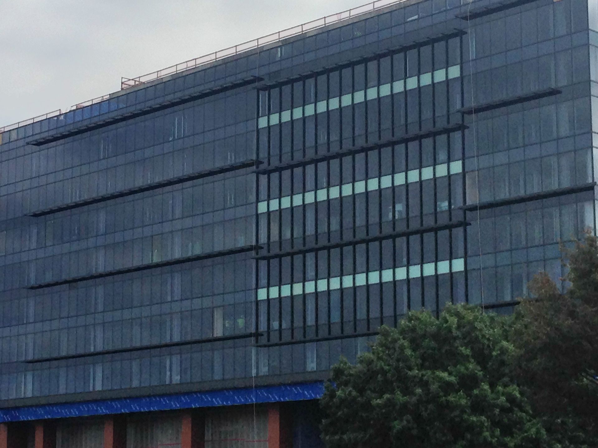 A large building with a lot of windows is surrounded by trees.