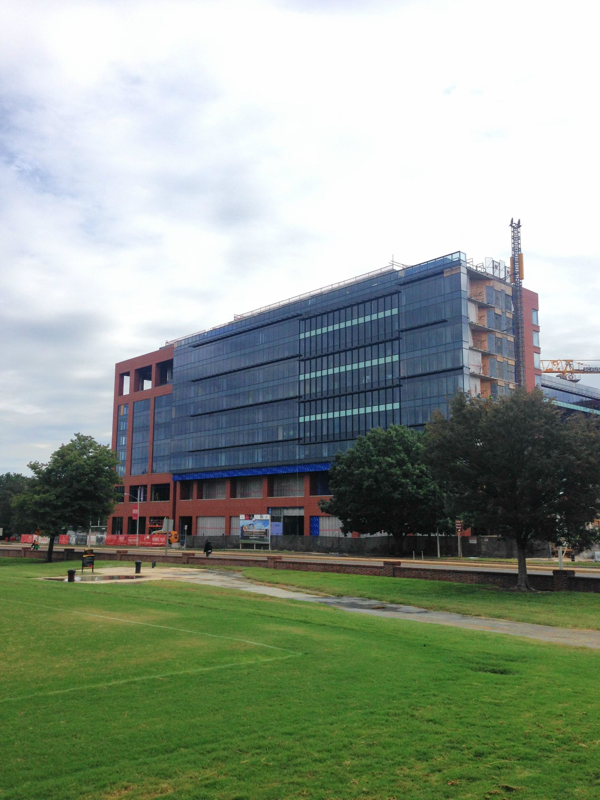 A large building with a lot of windows is being built in a park.