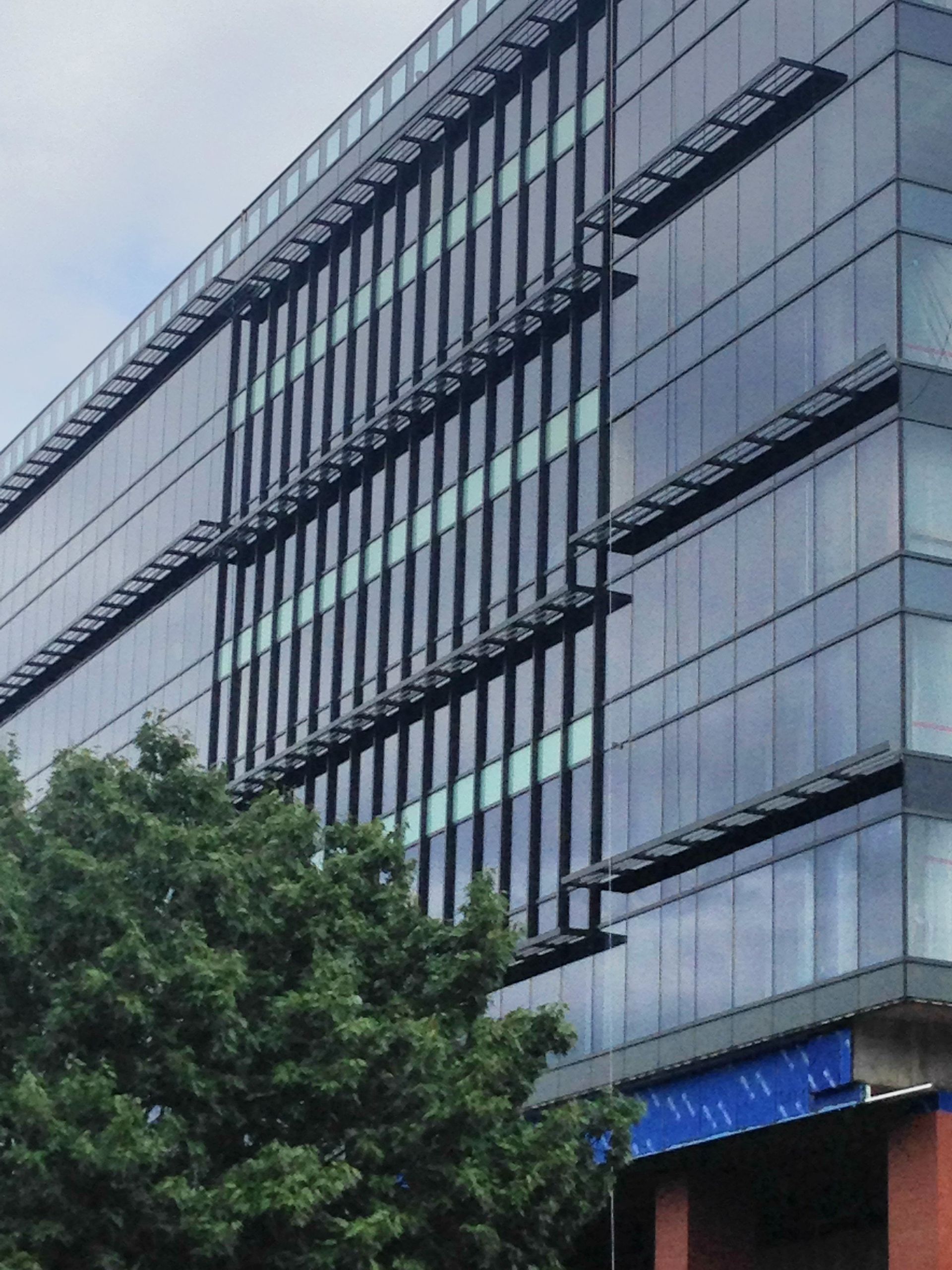 A very tall building with lots of windows and a blue sign