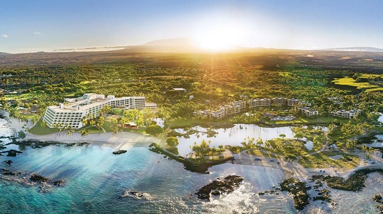 An aerial view of a tropical island with a sunset in the background.