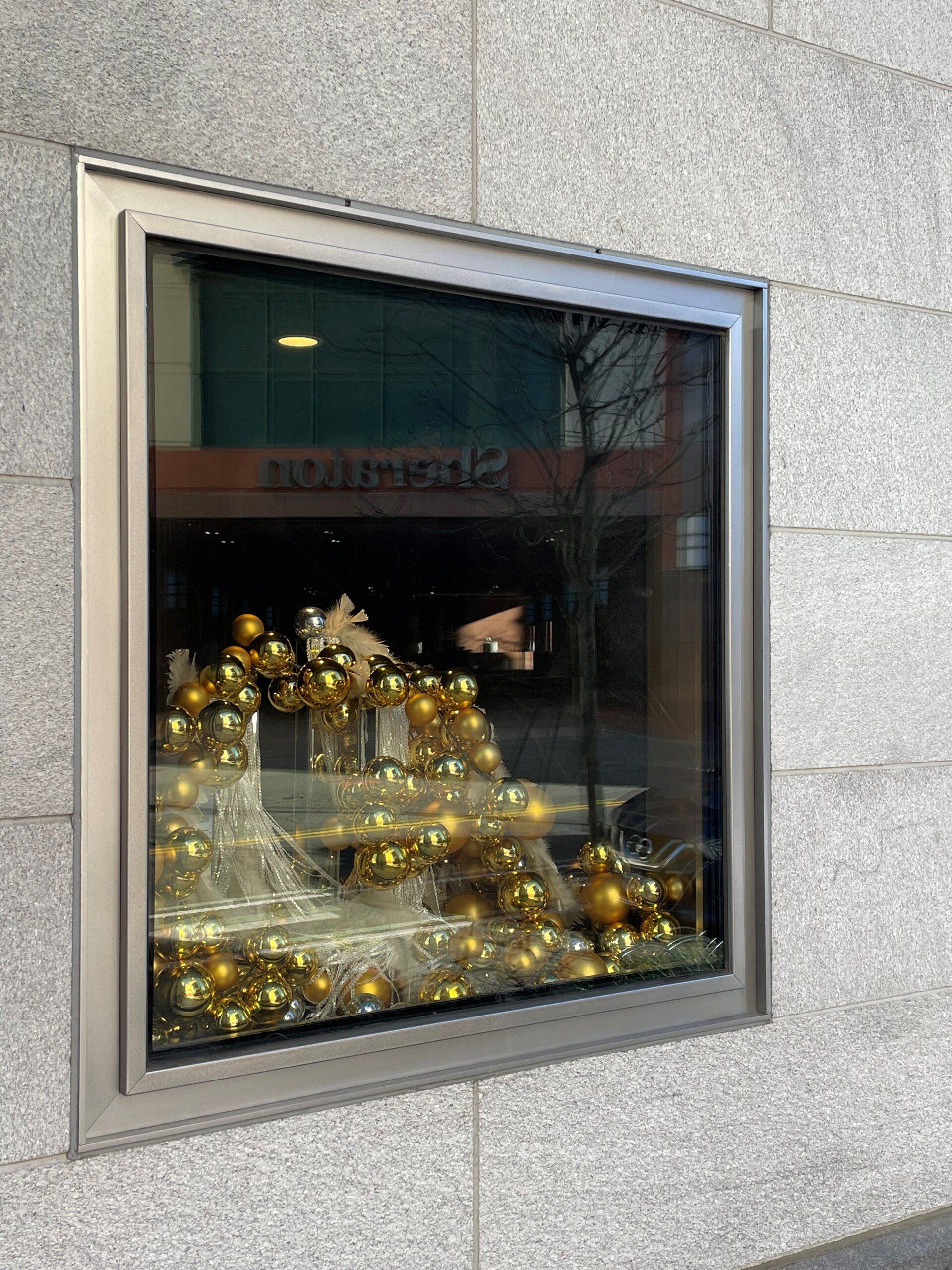 A window with a wreath and christmas decorations in it.