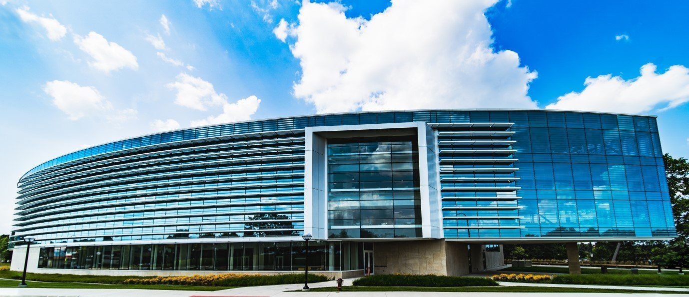 A large glass building with a blue sky in the background.