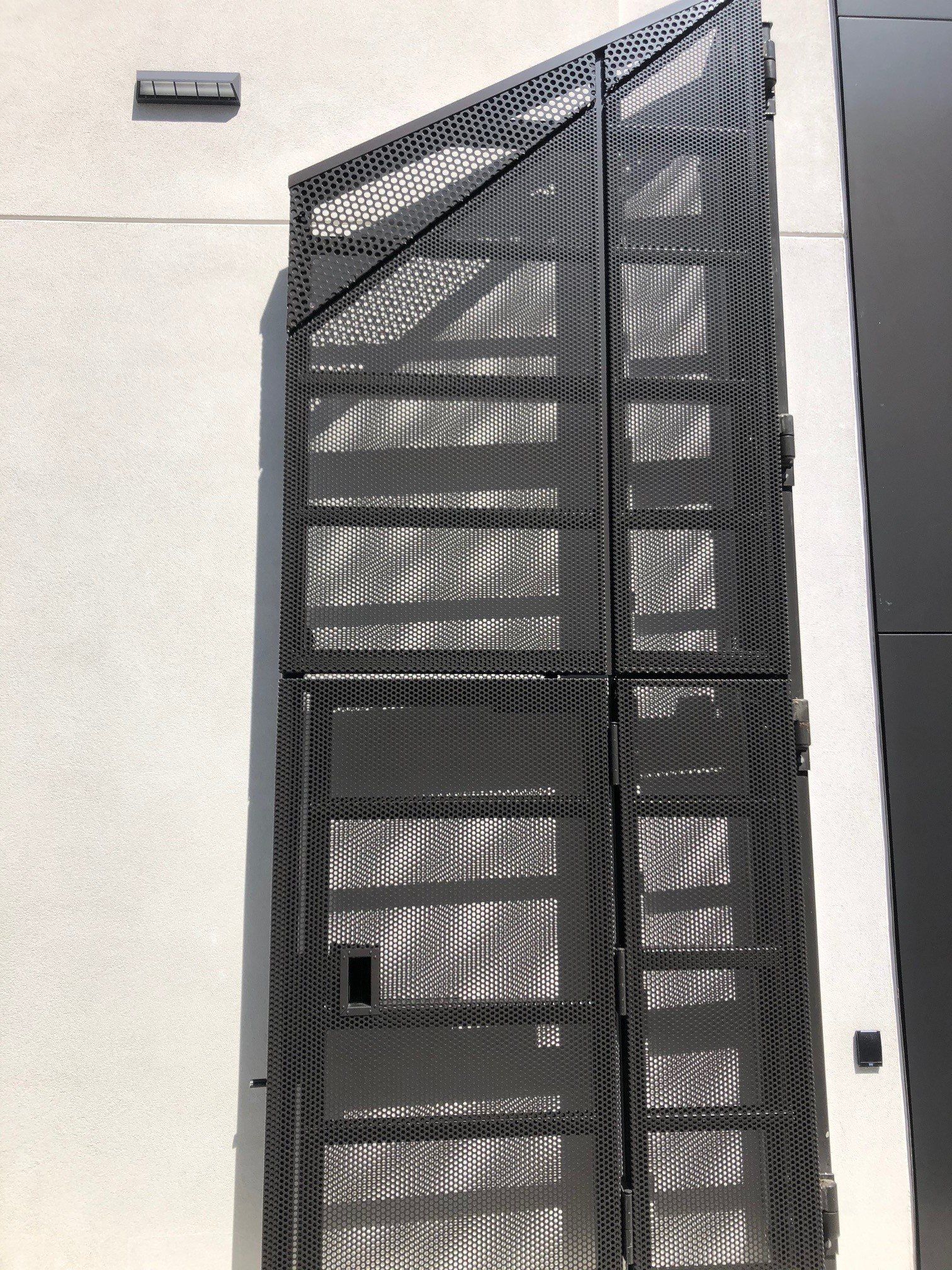 A close up of a metal gate on the side of a building.