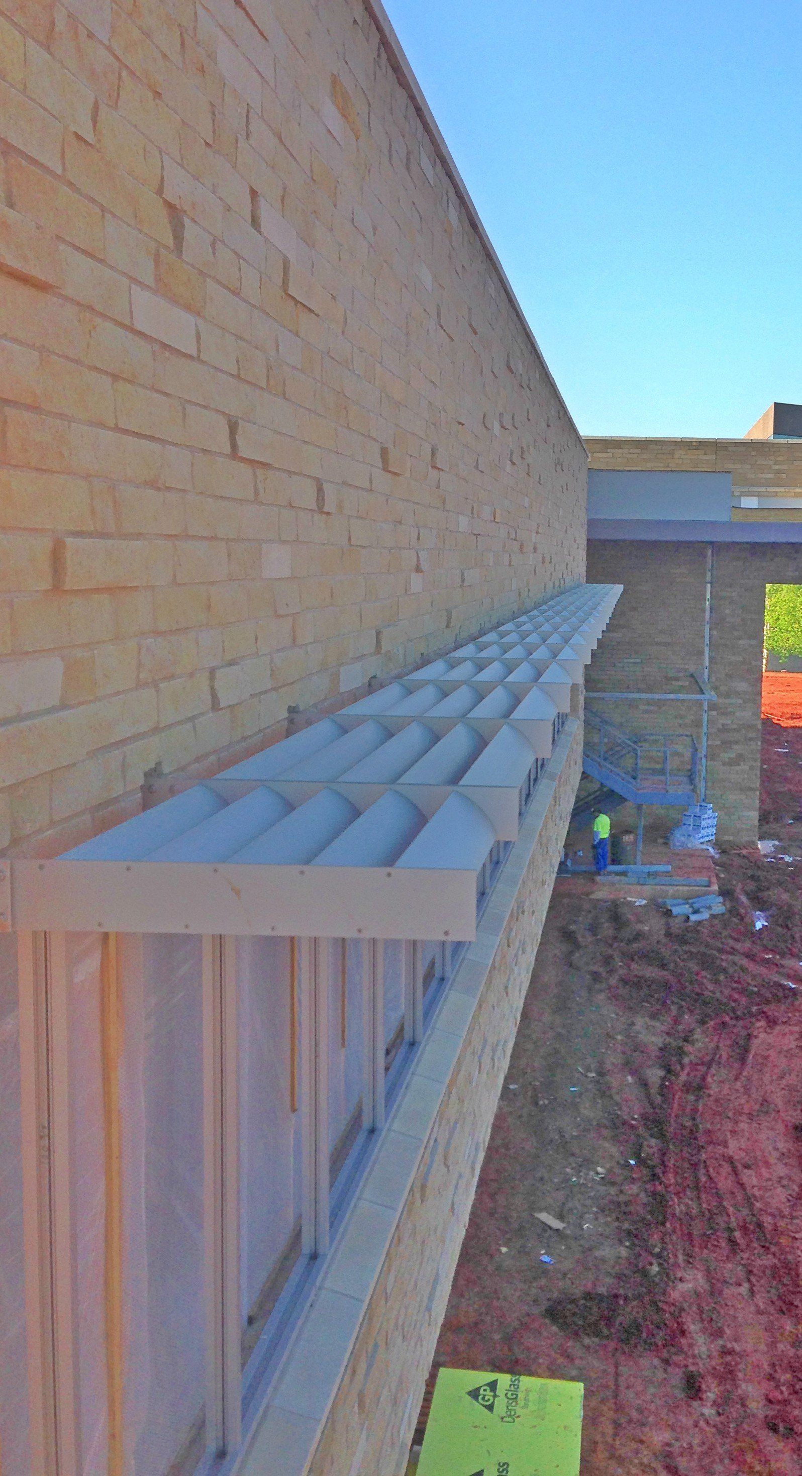 A brick wall with a shelf on the side of it.