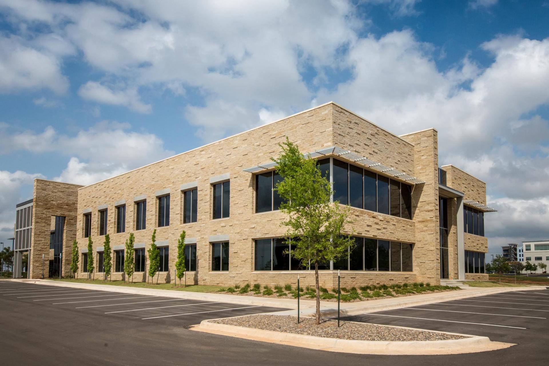 A large brick building with a lot of windows and a tree in front of it.