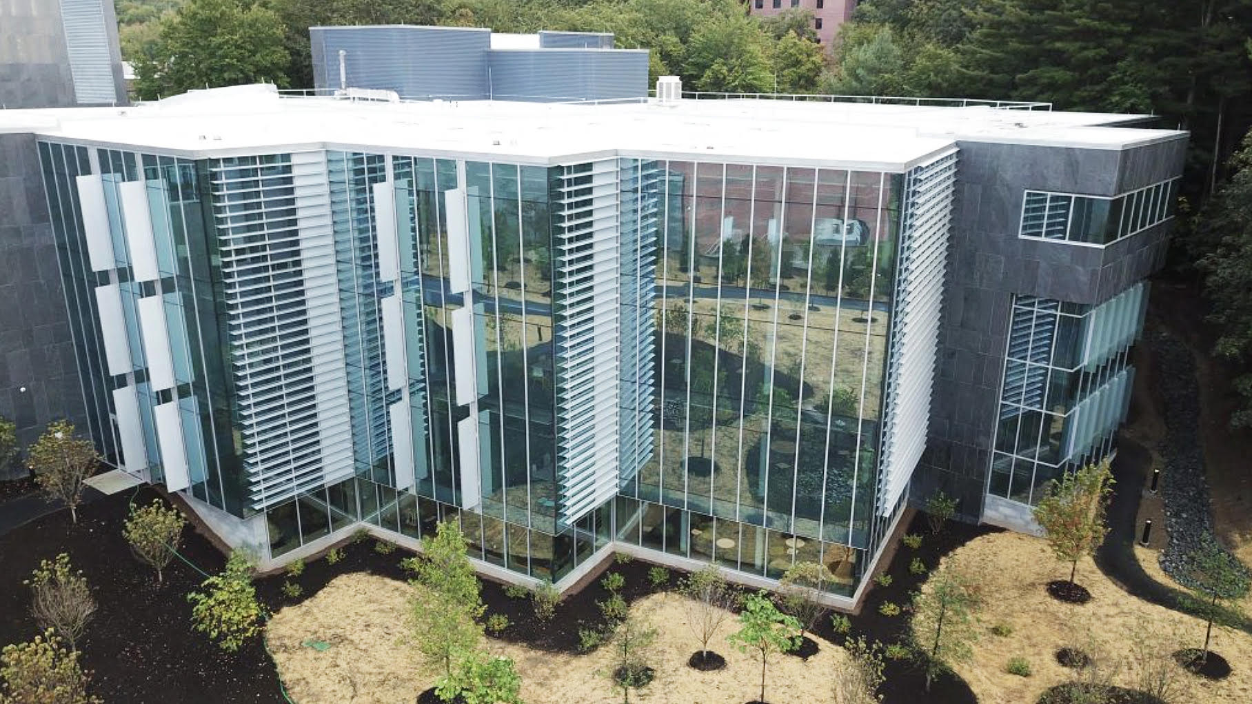 an aerial view of a large building with a lot of windows surrounded by trees .