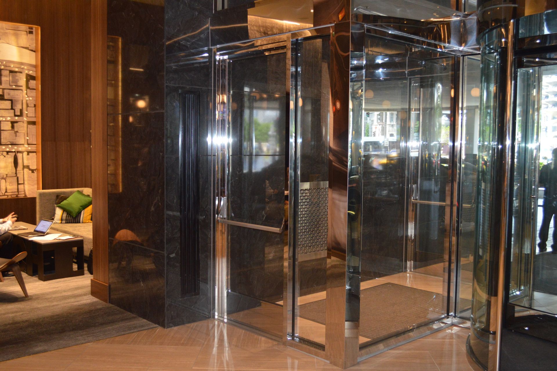 A hotel lobby with a revolving door and a couch.