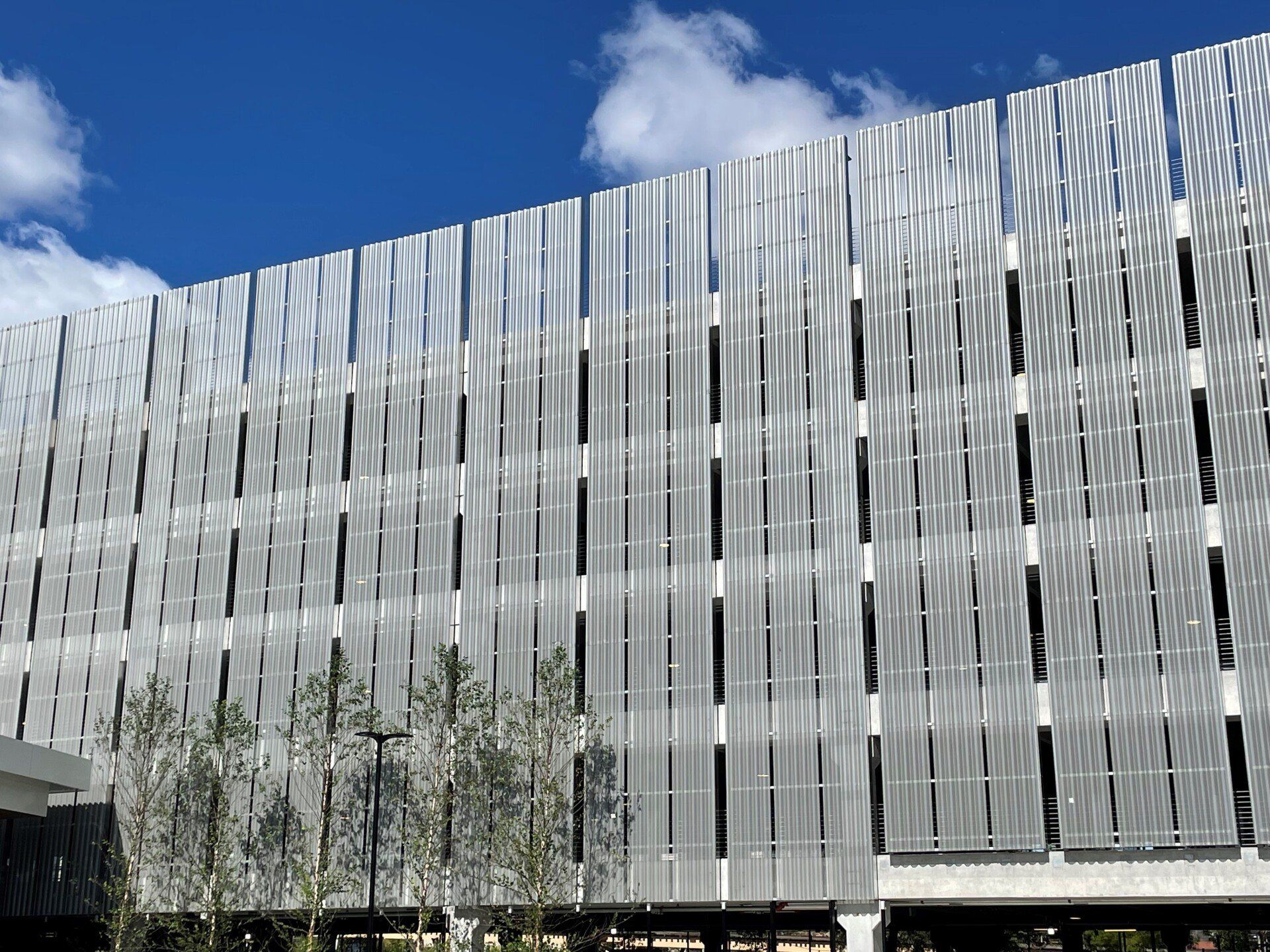 A large building with a lot of windows and a blue sky in the background