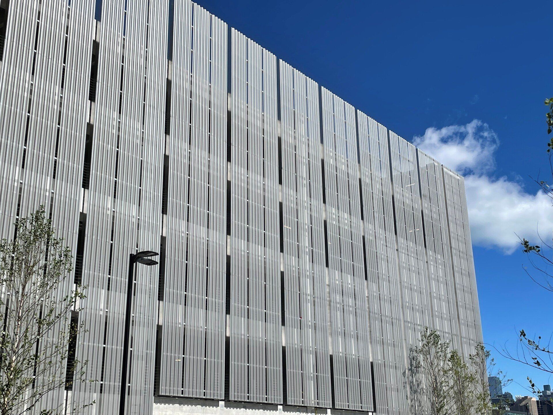A large building with a lot of windows and a blue sky in the background.